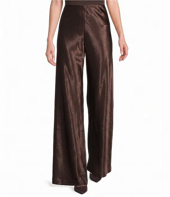 A model wearing high-waisted, wide-leg trousers in a dark brown satin fabric, shown from the waist down against a plain white background.