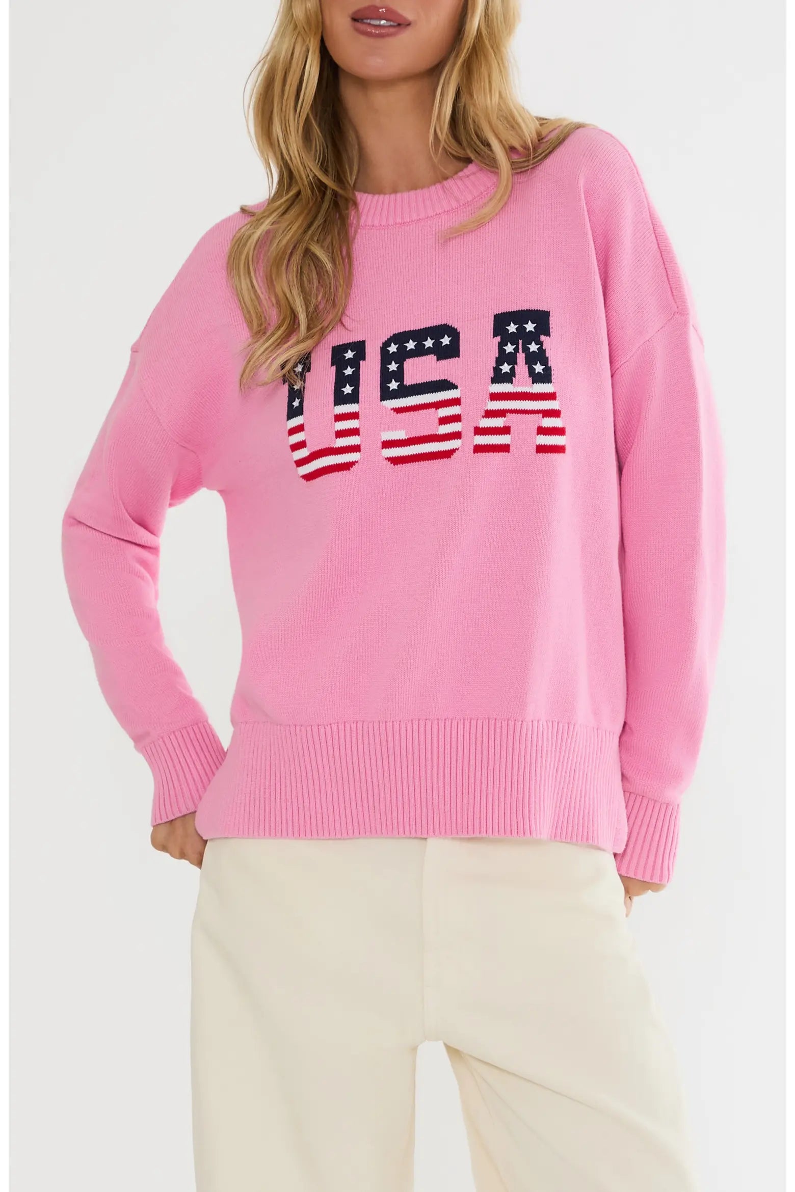 Pink sweater with 'USA' text and American flag design on a white background