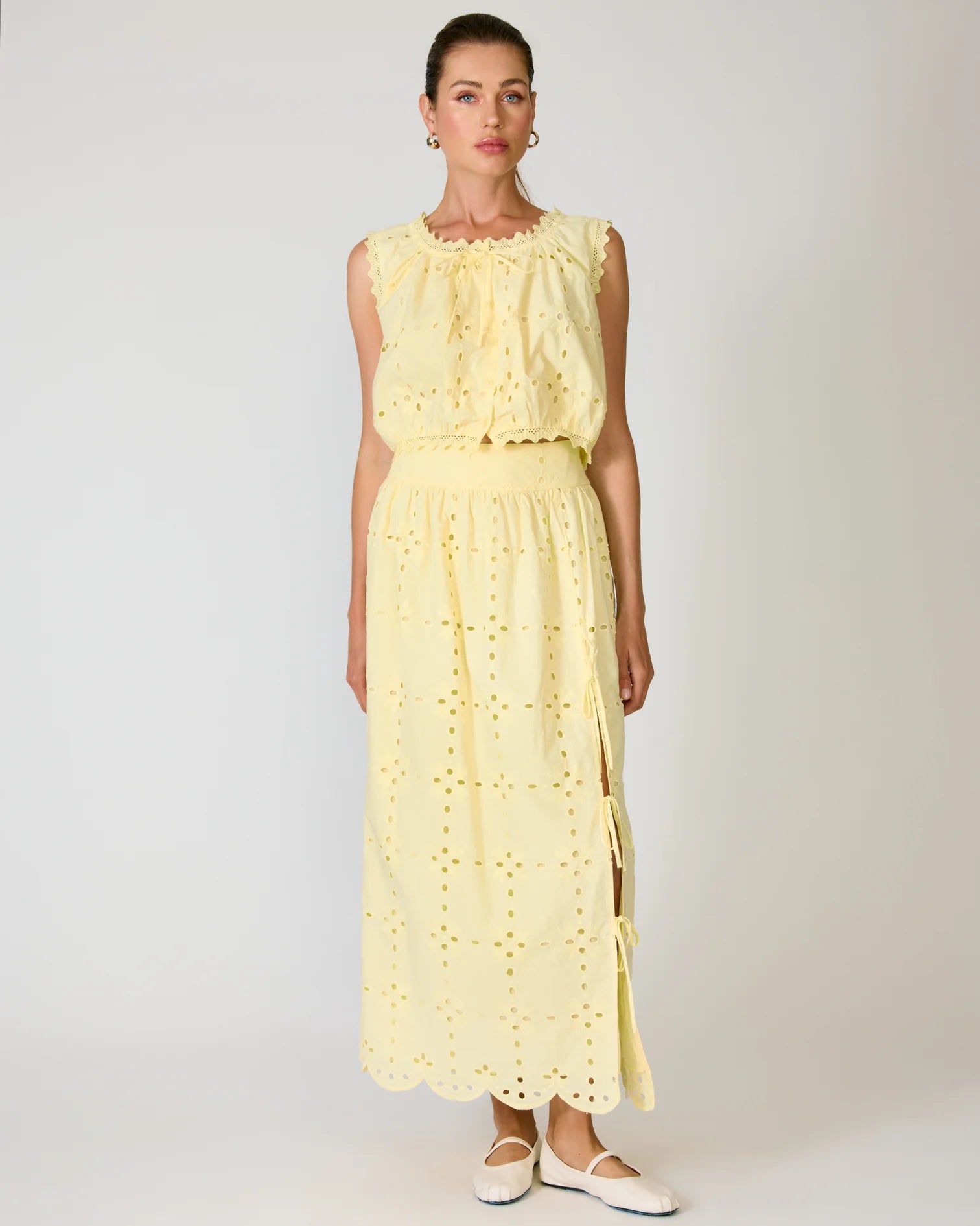 Woman wearing a yellow set against a white background