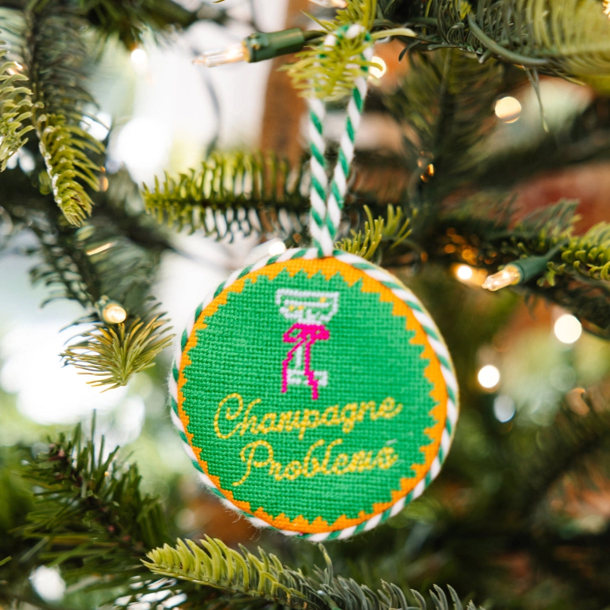 Decorative ornament with 'Champagne Problems' text on a Christmas tree.