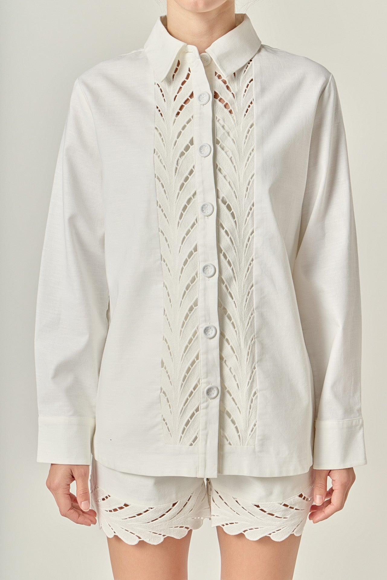 White lace-trimmed shirt and shorts set on a neutral background