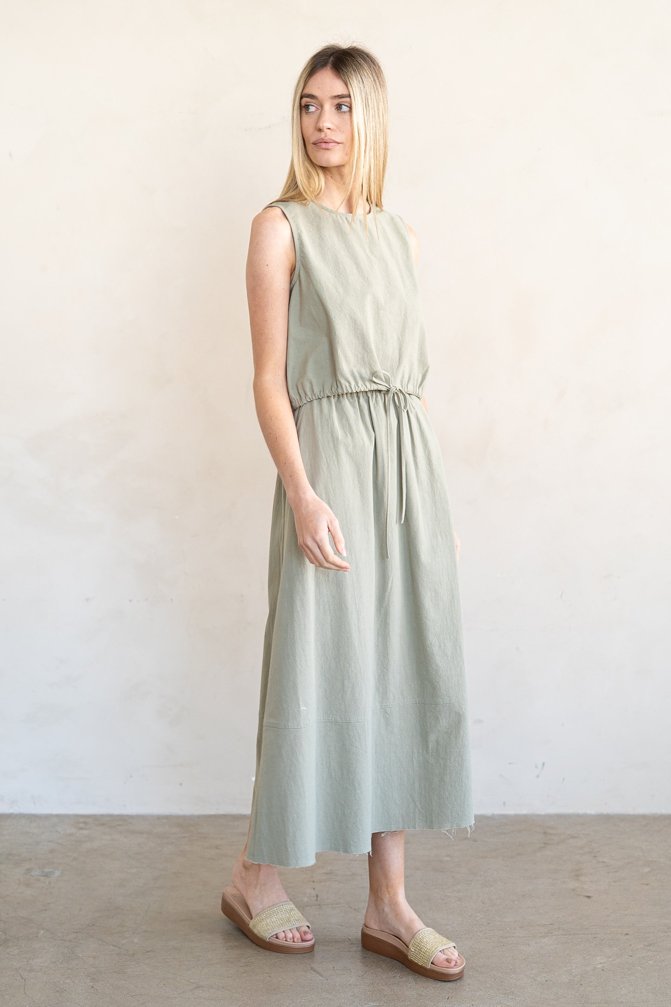 Woman wearing a light green dress against a plain background