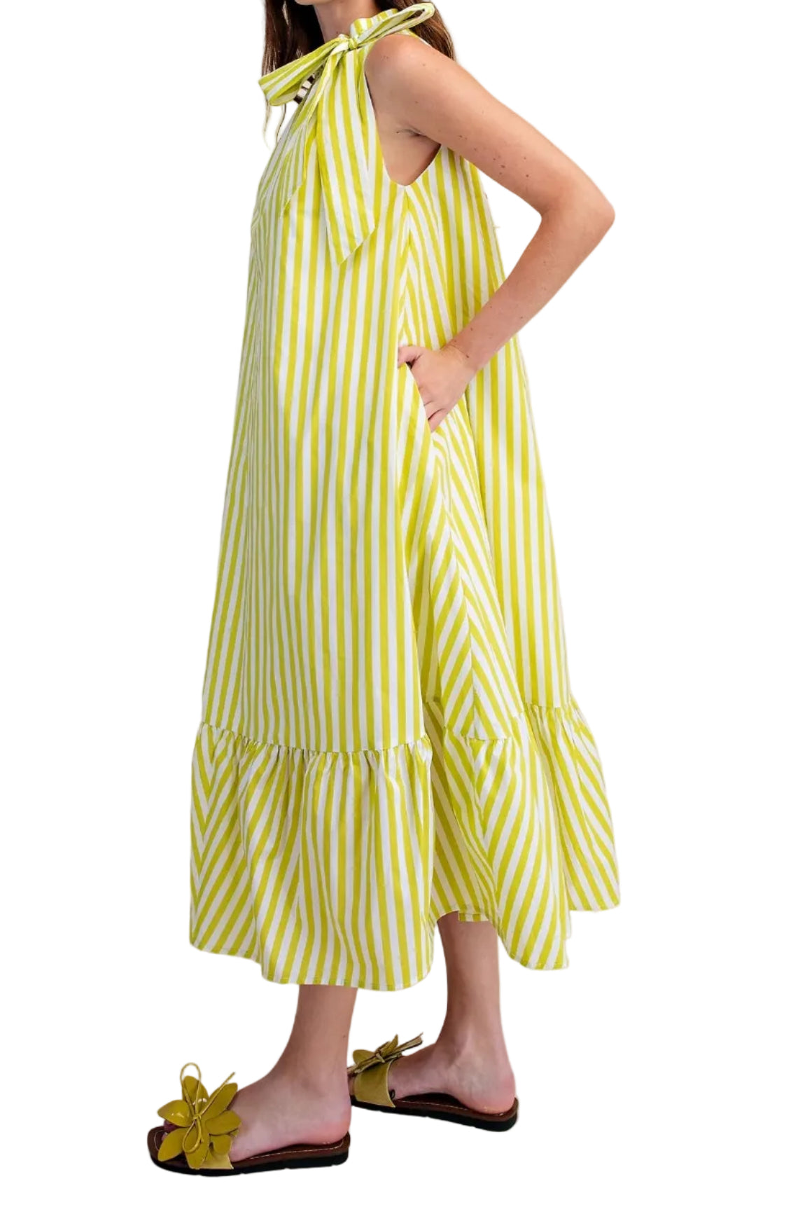 Woman wearing a yellow and white striped dress on a plain background