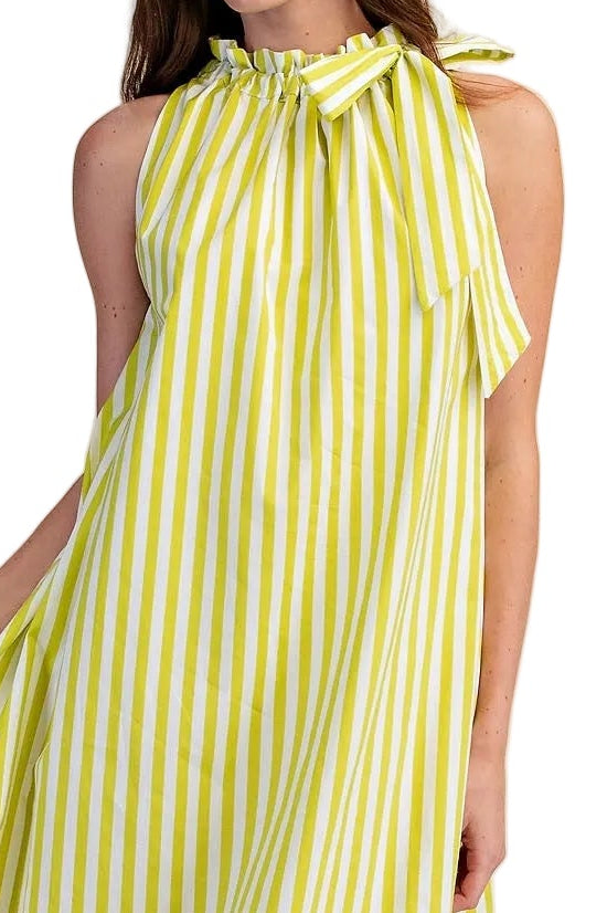 Woman wearing a yellow and white striped dress on a beige background