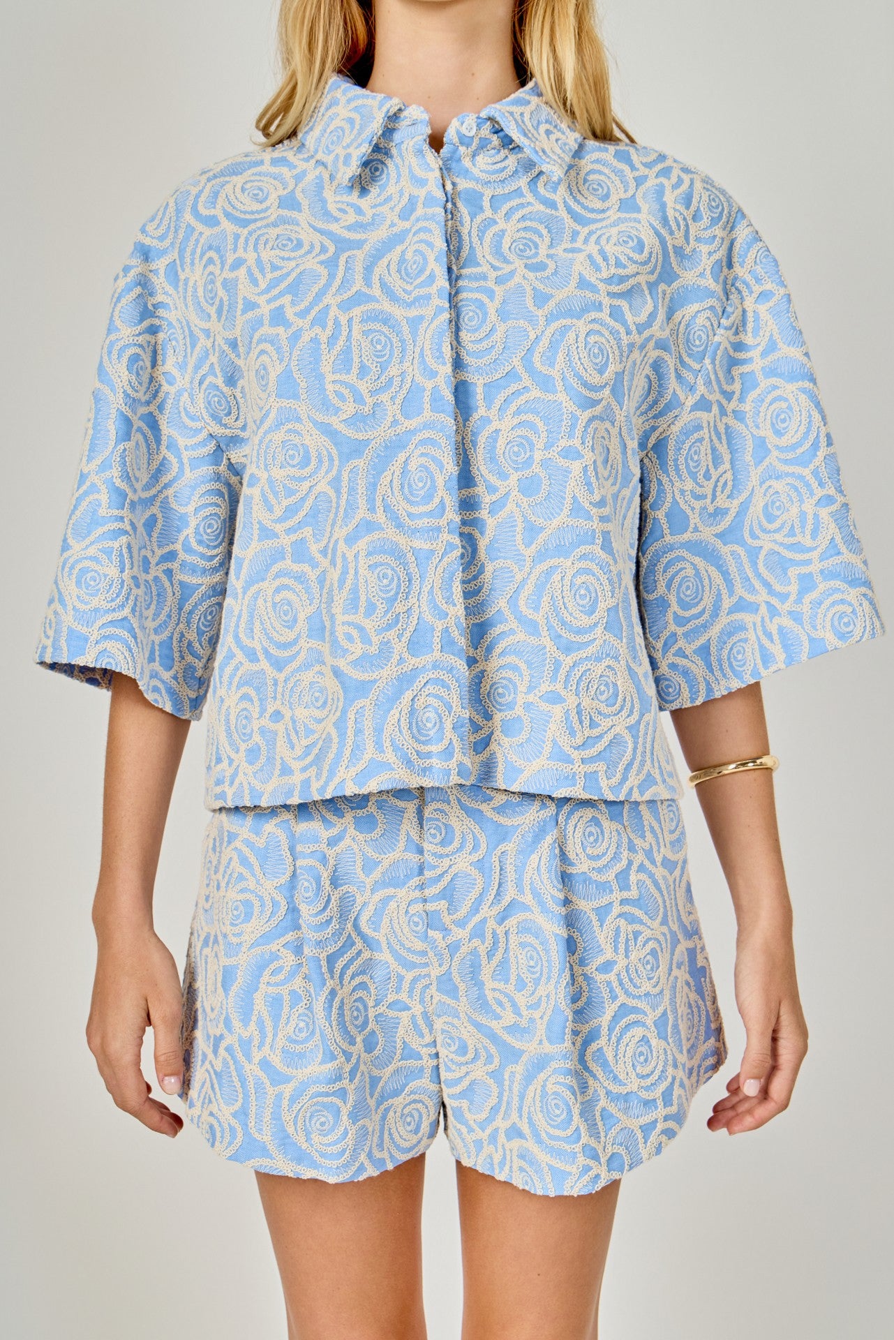Person wearing a blue and white patterned outfit on a plain background