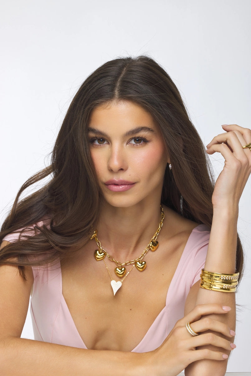 Woman wearing gold jewelry against a white background