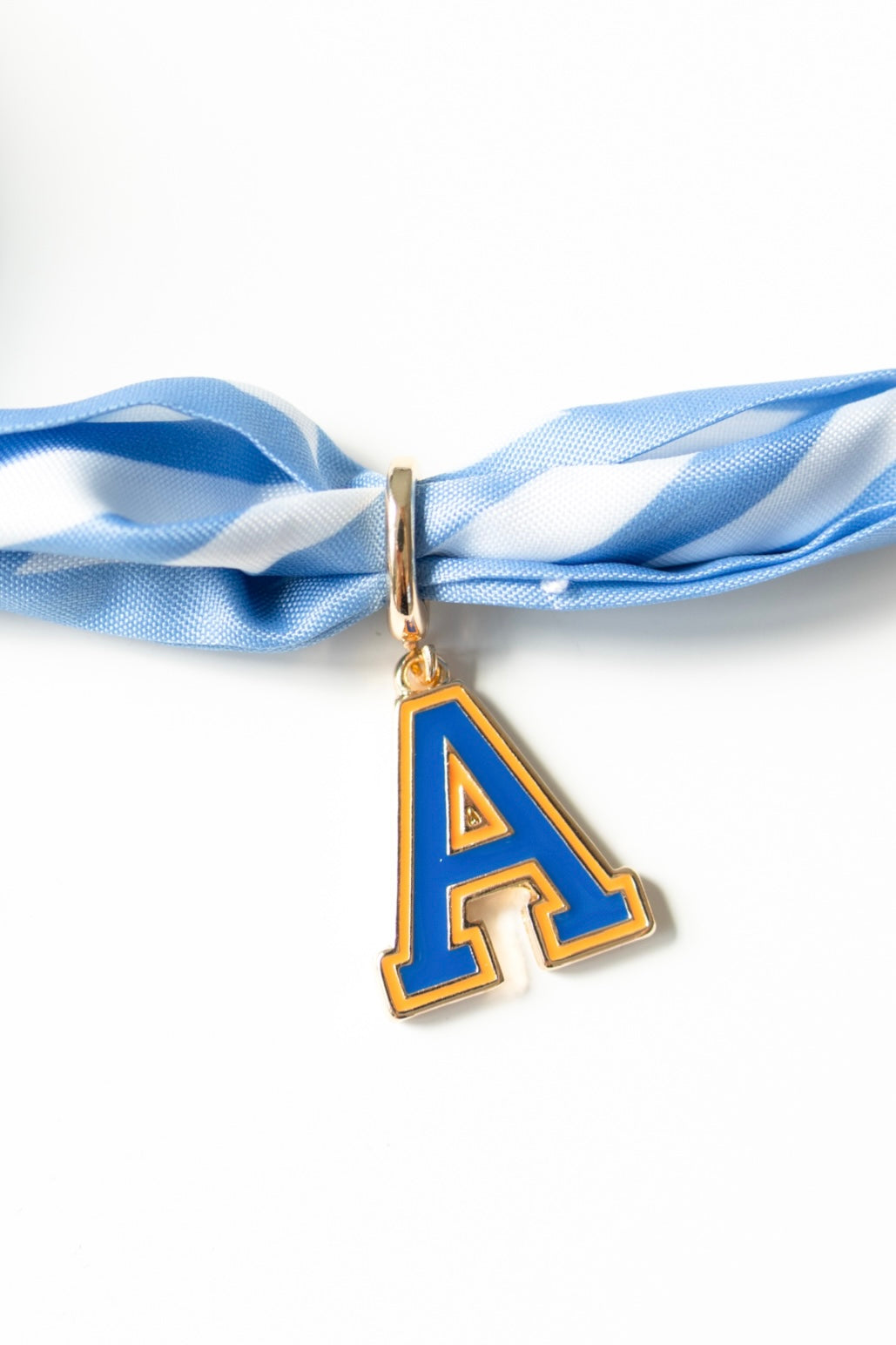 Blue letter 'A' pendant on a blue and white striped ribbon against a white background