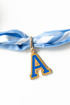 Blue letter 'A' pendant on a blue and white striped ribbon against a white background