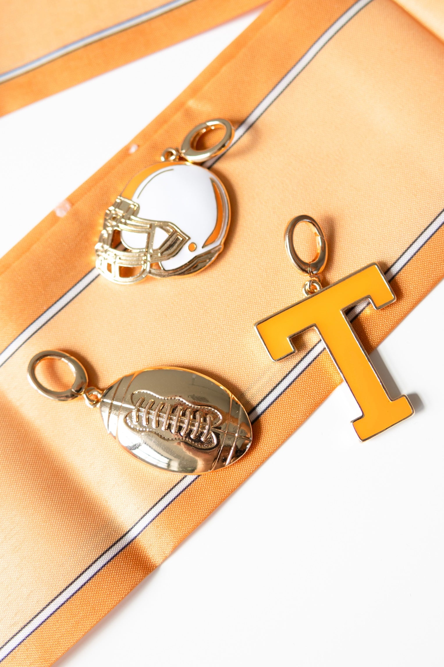 Decorative game day scarf pendant charms on a orange scarf