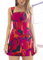 Woman wearing a colorful floral dress with a white background