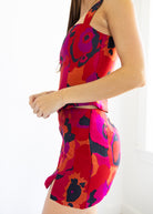 Woman wearing a colorful floral dress on a white background