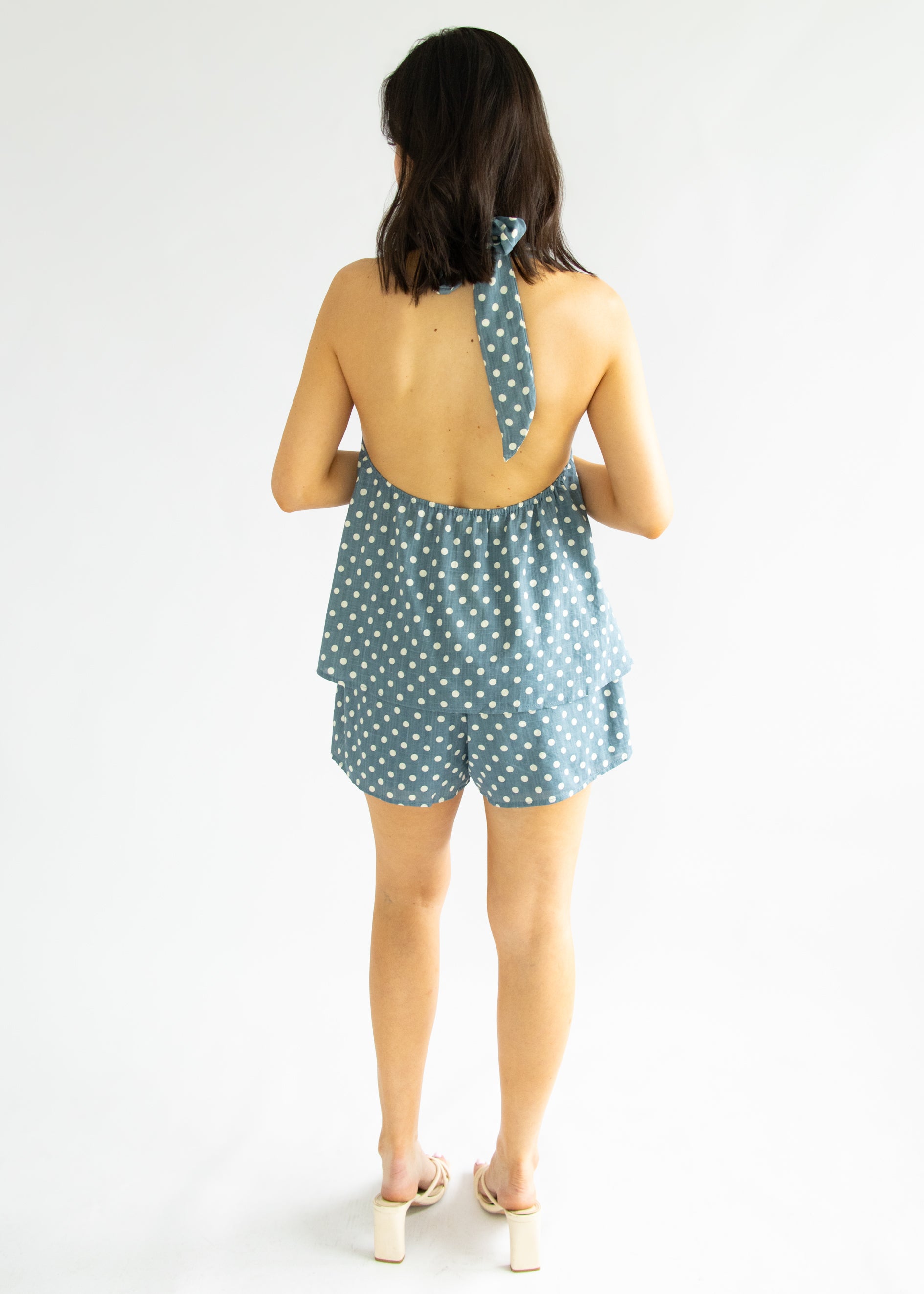Woman wearing a polka dot romper on a white background