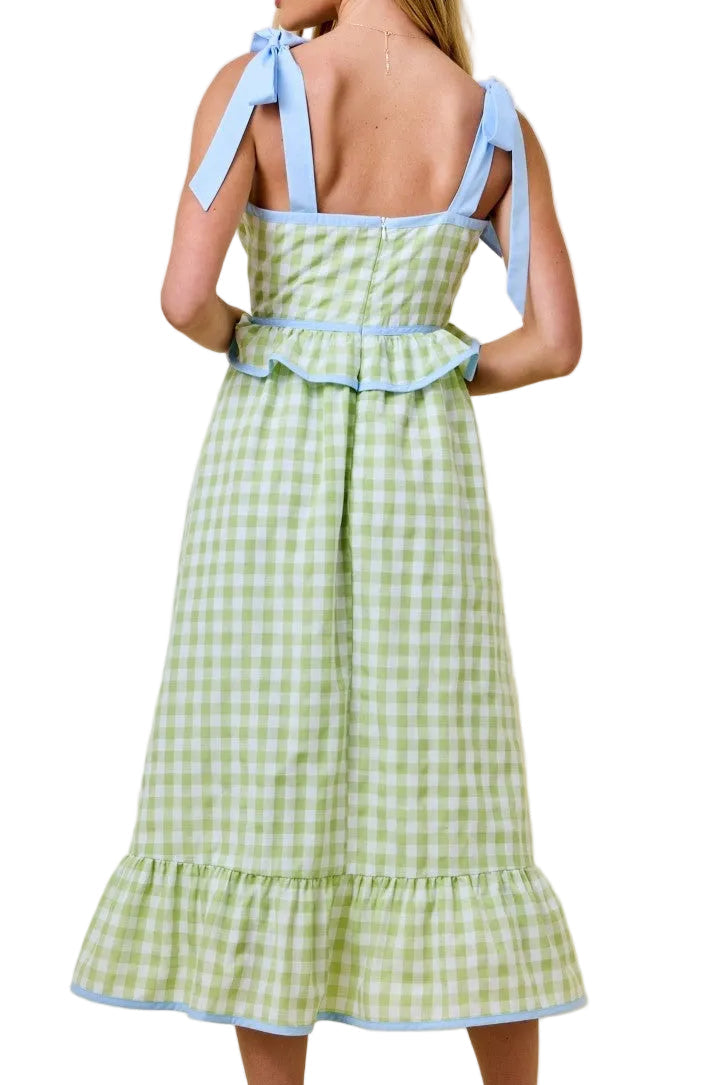 Woman wearing a green checkered dress with blue accents on a beige background