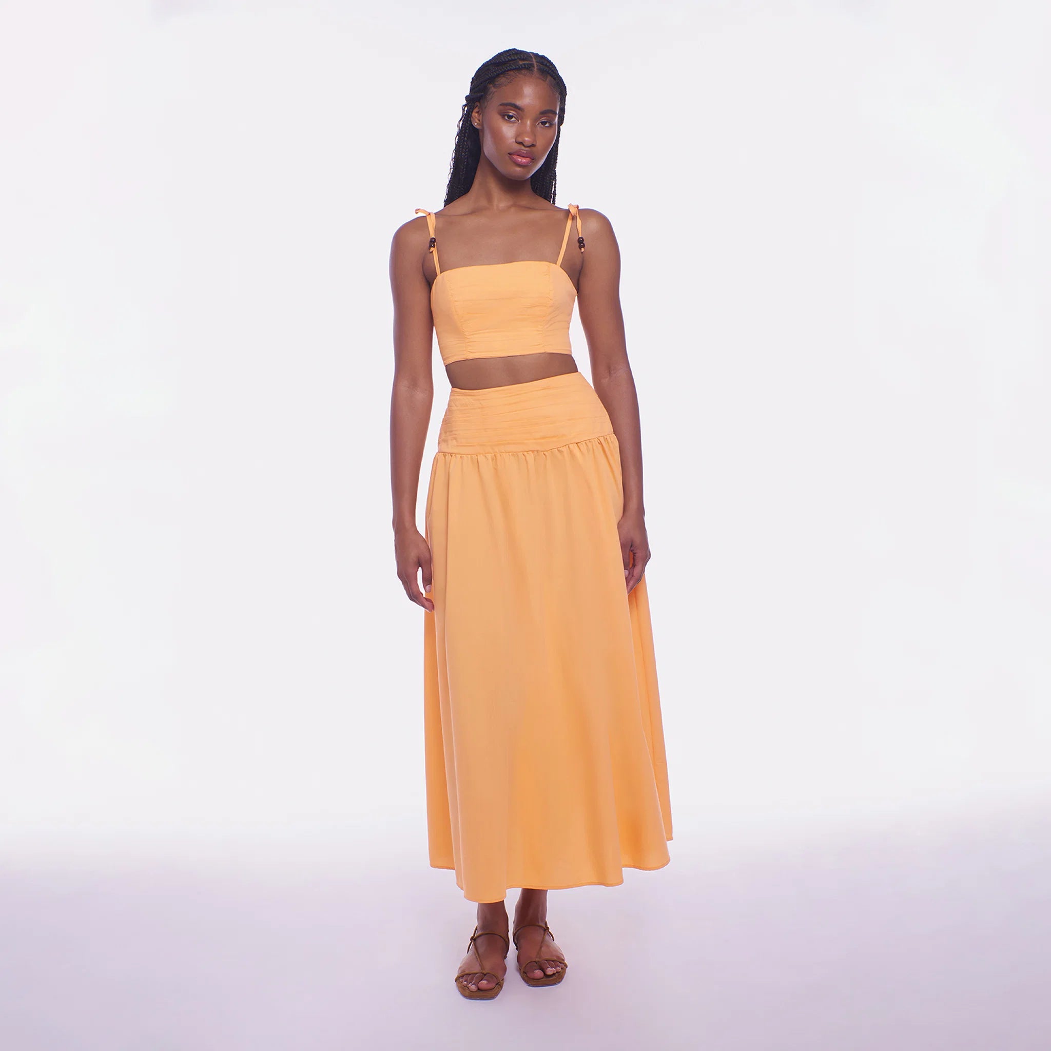 Woman wearing a yellow two-piece outfit on a white background