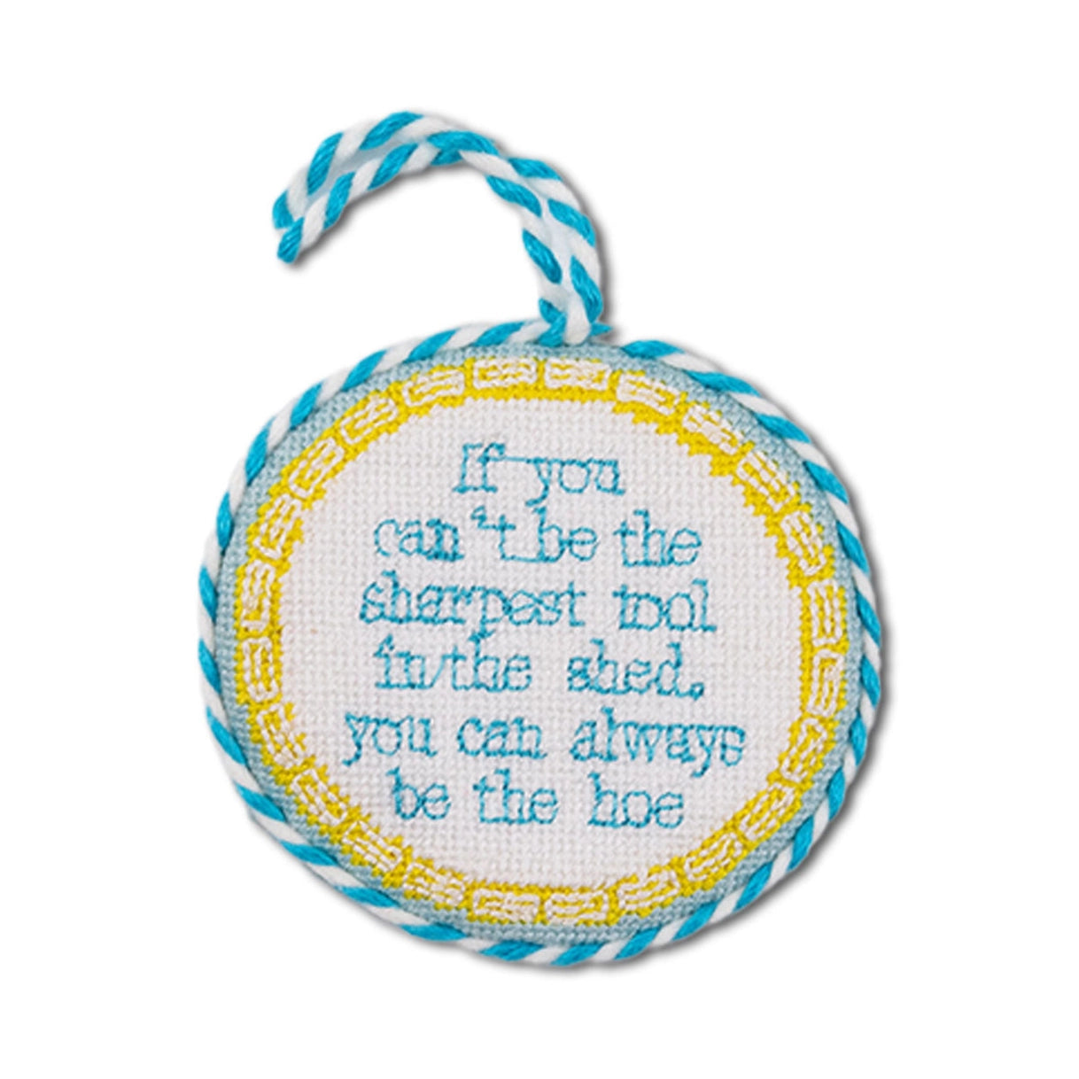 Round embroidered item with text and blue and white rope, on a white background