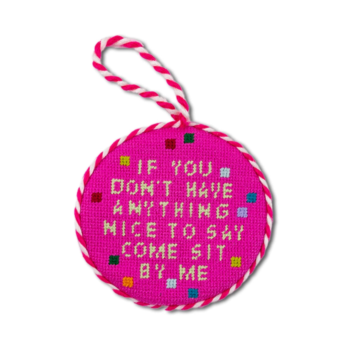 Pink round needlepoint ornament with text and candy cane handle on a white background
