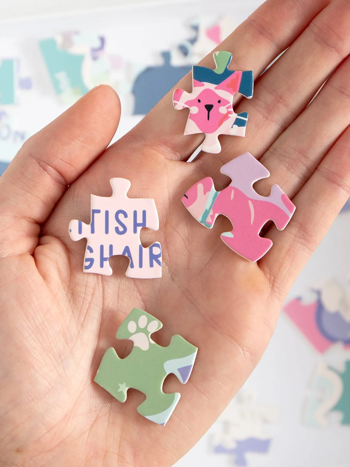 Hand holding colorful puzzle pieces with text and designs