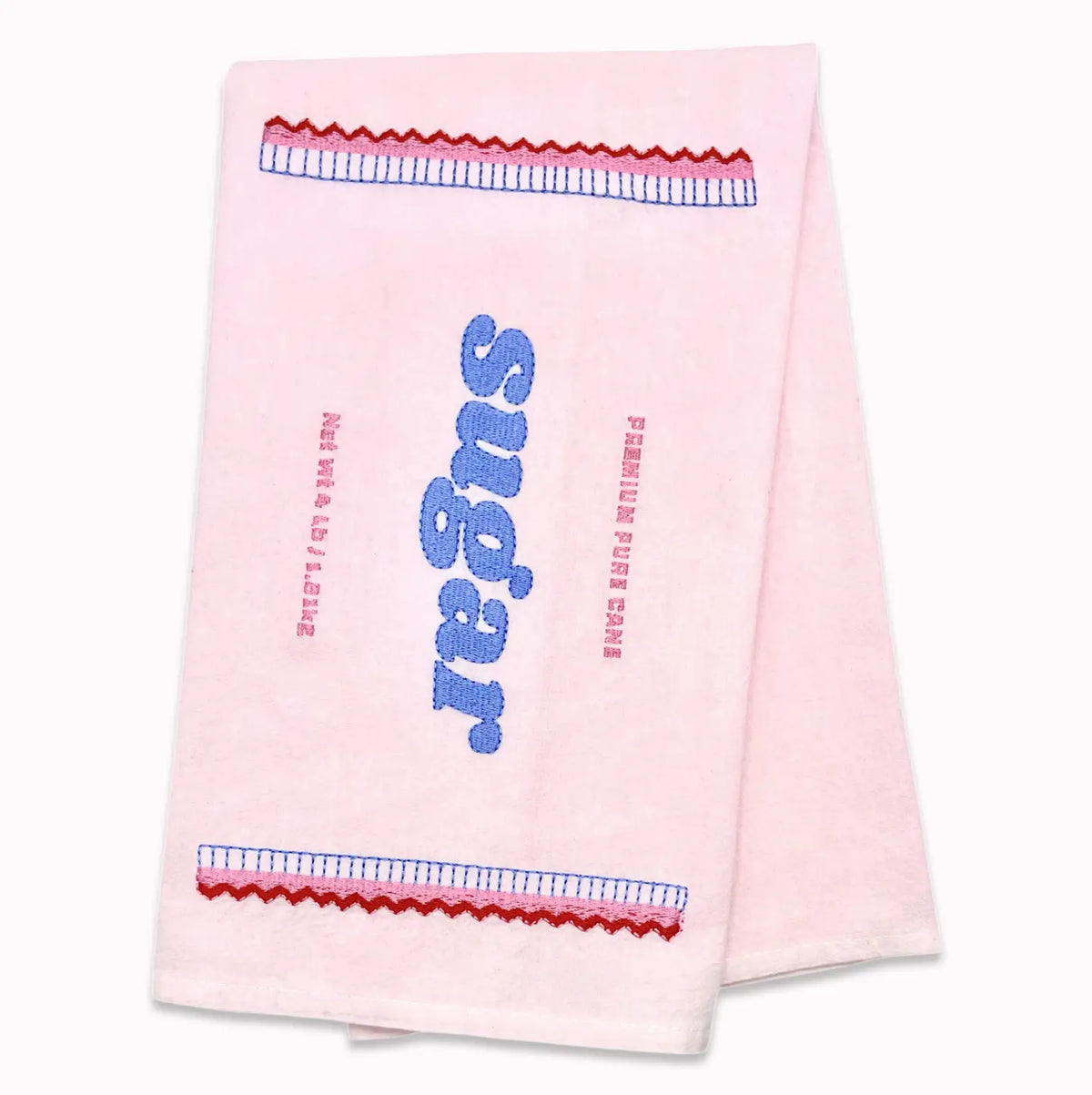 A light pink tea towel with 'sugar' embroidered in blue down the center, flanked by red and blue decorative borders, shown on a plain white background.