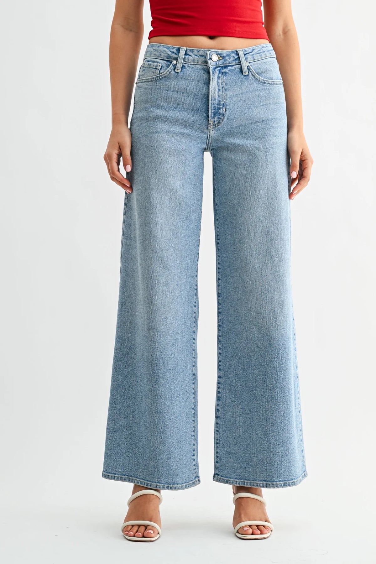 Person wearing light blue wide-leg jeans on a white background