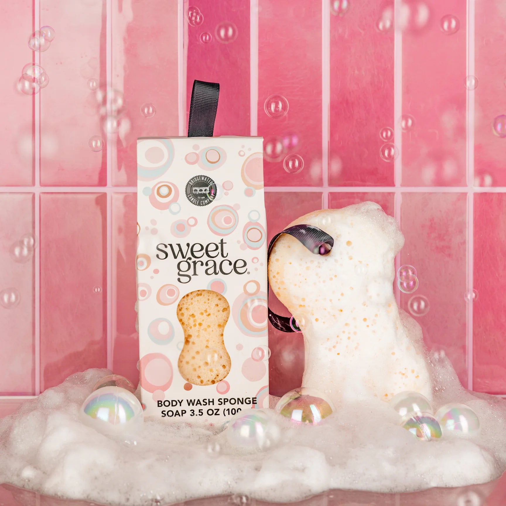 Body wash sponge with packaging labeled 'sweet grace' in a bathtub setting.