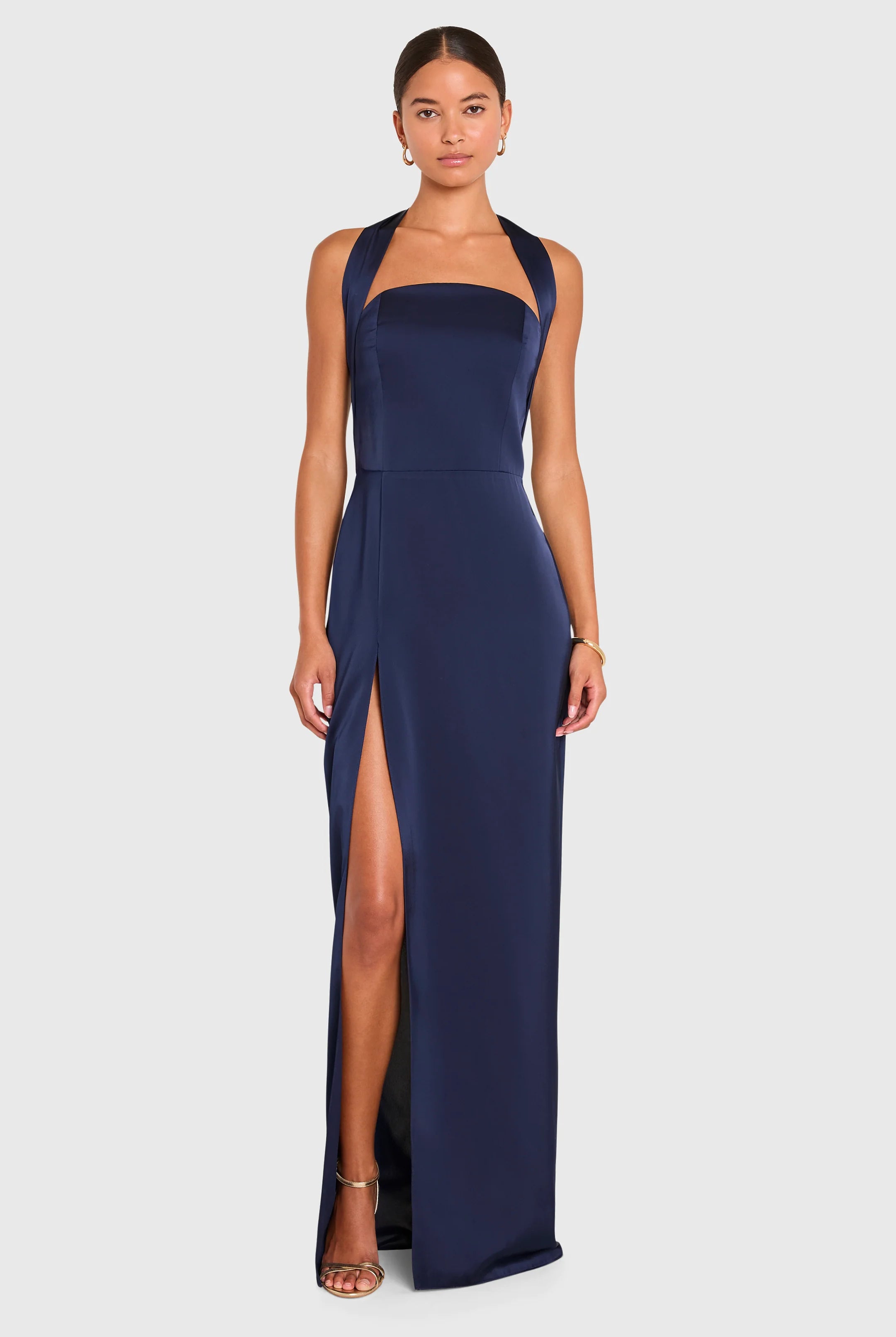 Navy blue halter neck gown with a high slit on a white background