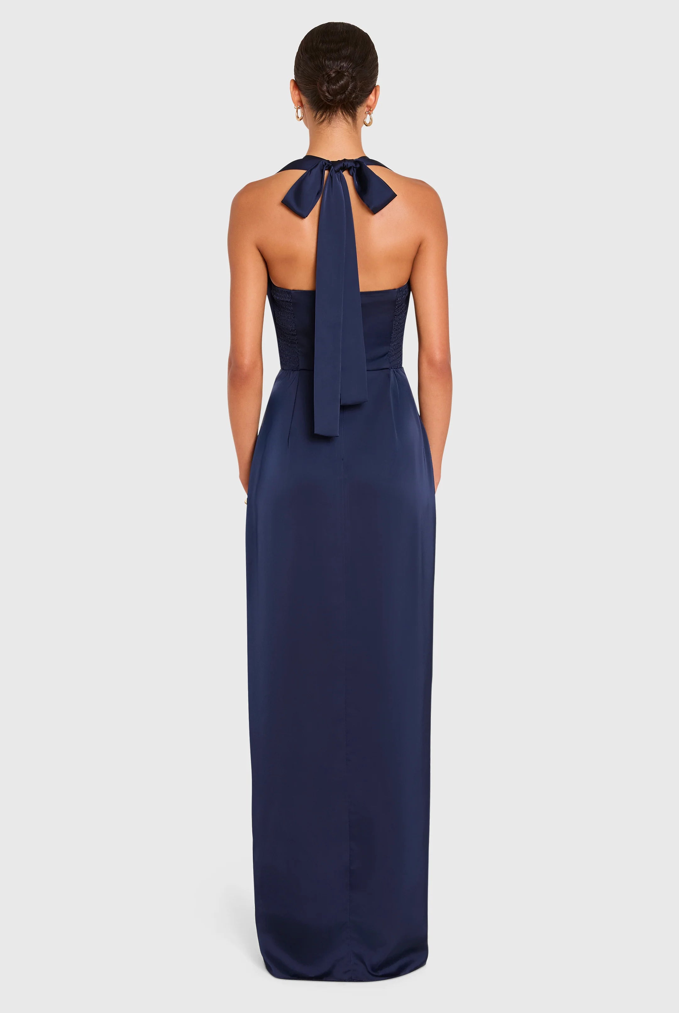 Navy blue halter neck gown with a bow detail on a white background