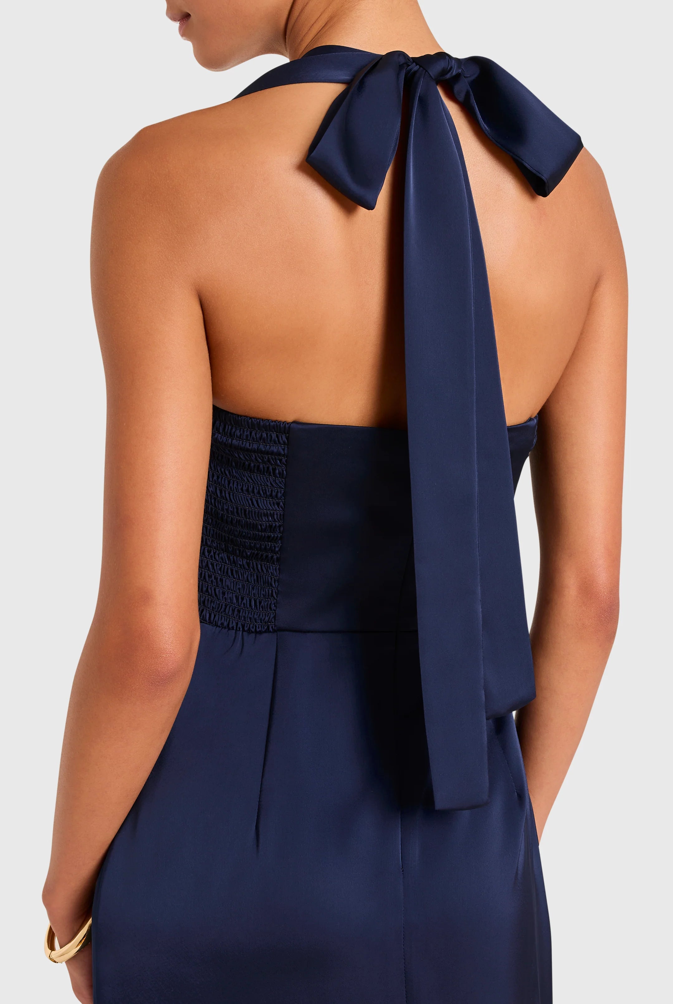 Navy blue halter dress with a bow detail on a white background