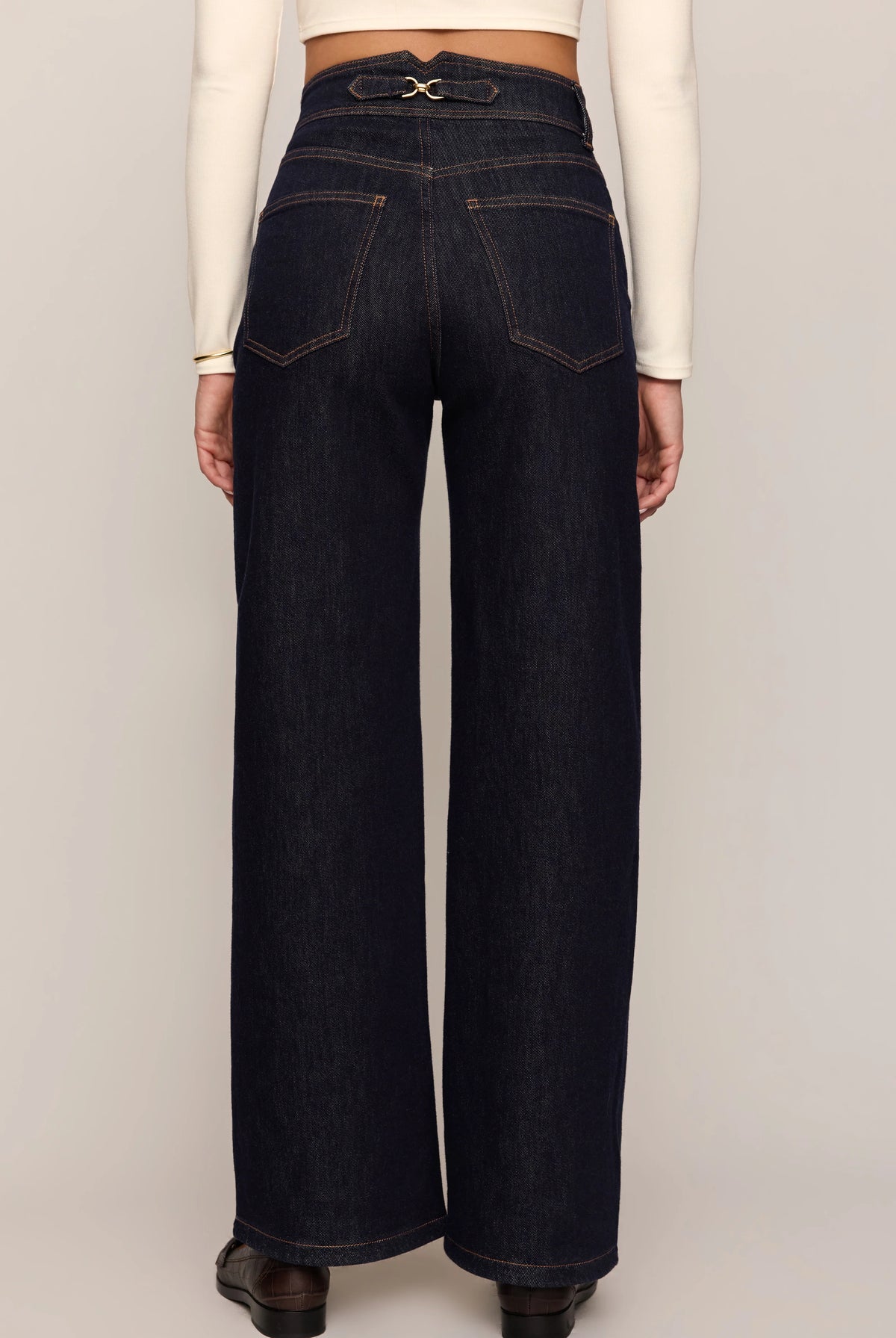 Person wearing dark blue jeans with a white background