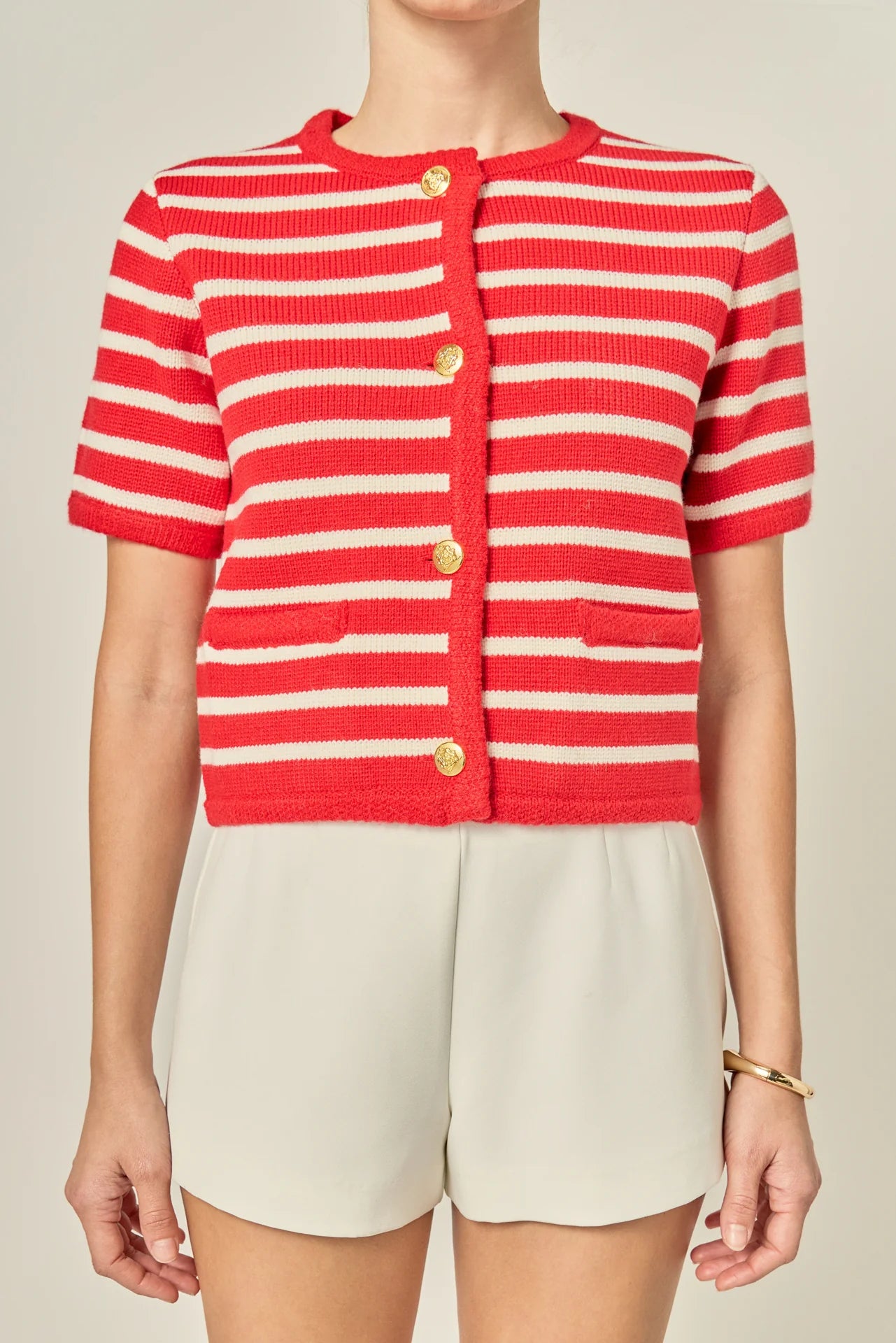 Red and white striped cardigan worn by a person on a neutral background
