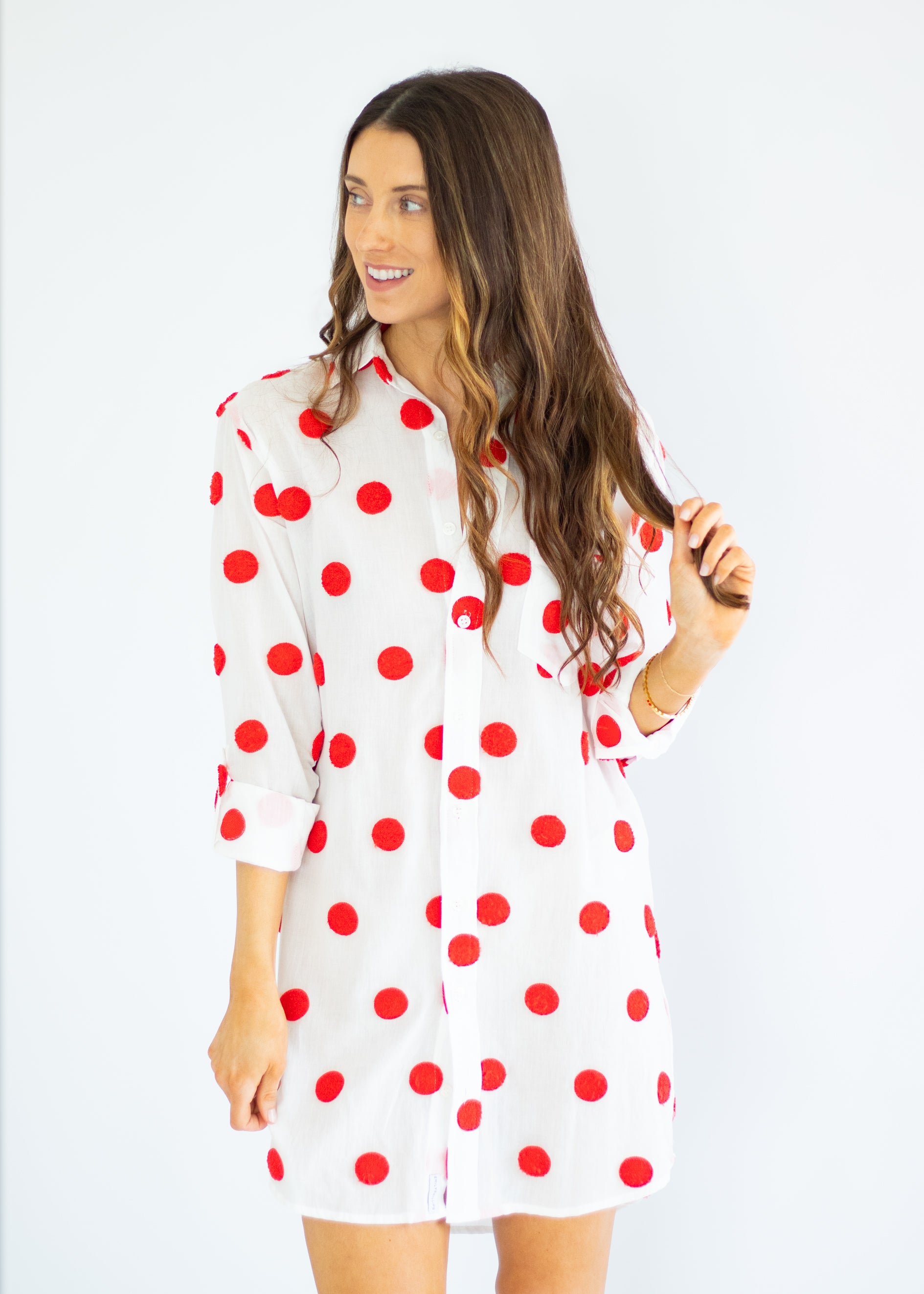 Woman wearing a white dress with red polka dots on a white background