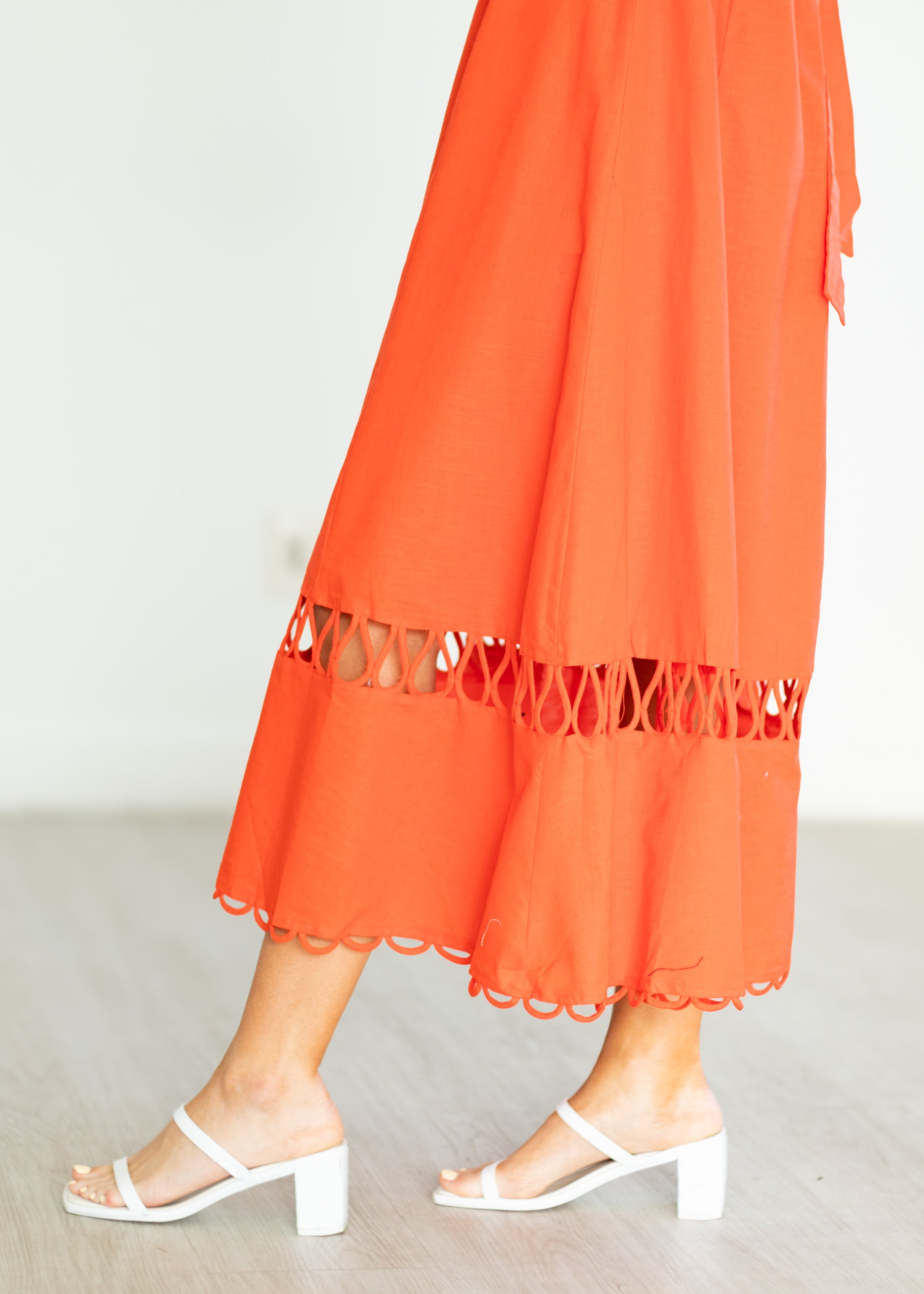 Orange dress with lace trim worn by a person on a plain background