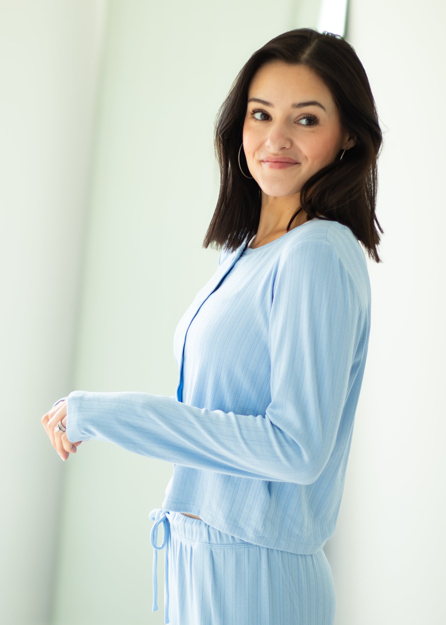 Woman wearing a light blue outfit against a white background