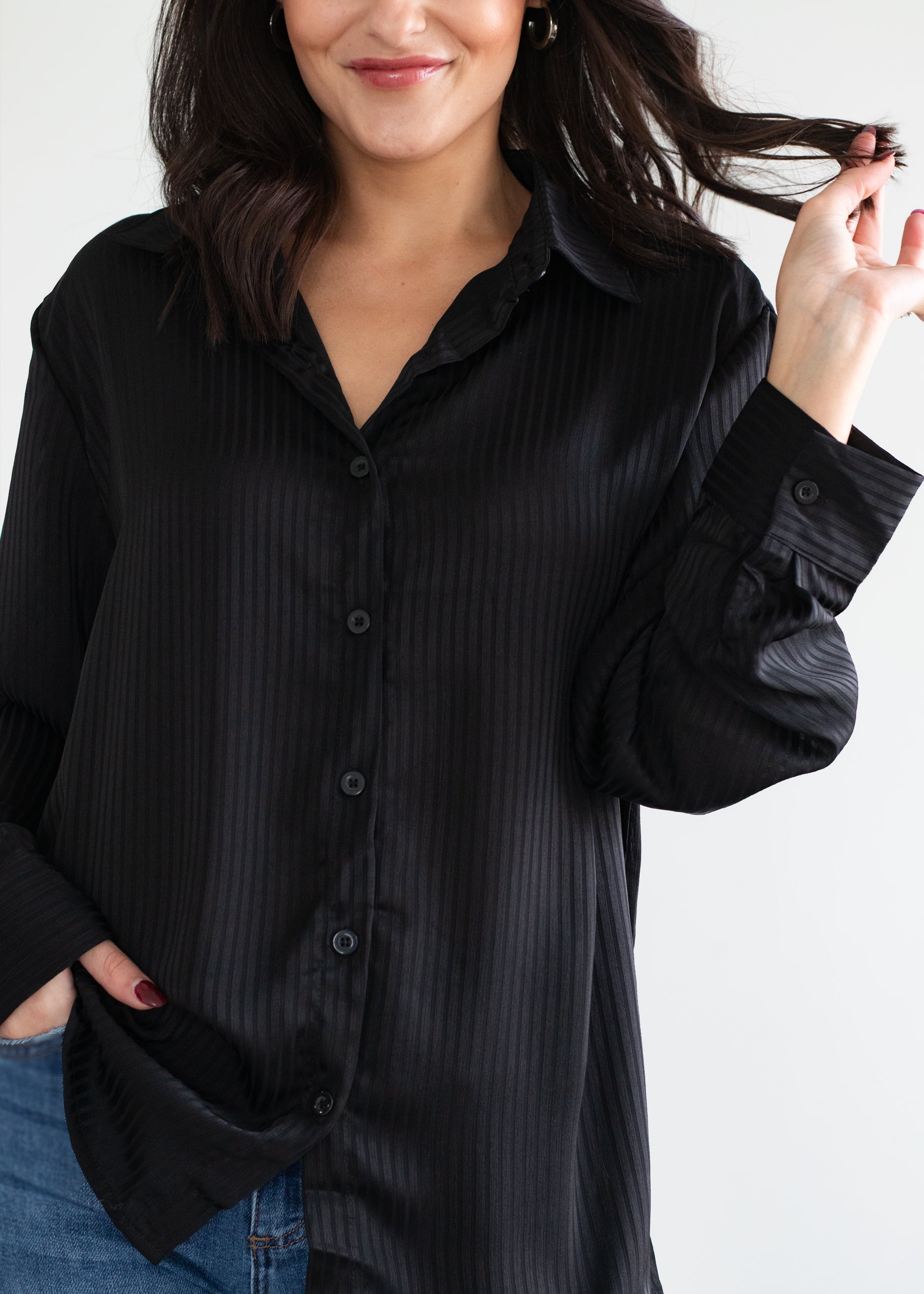 Woman wearing a black button-up shirt against a white background