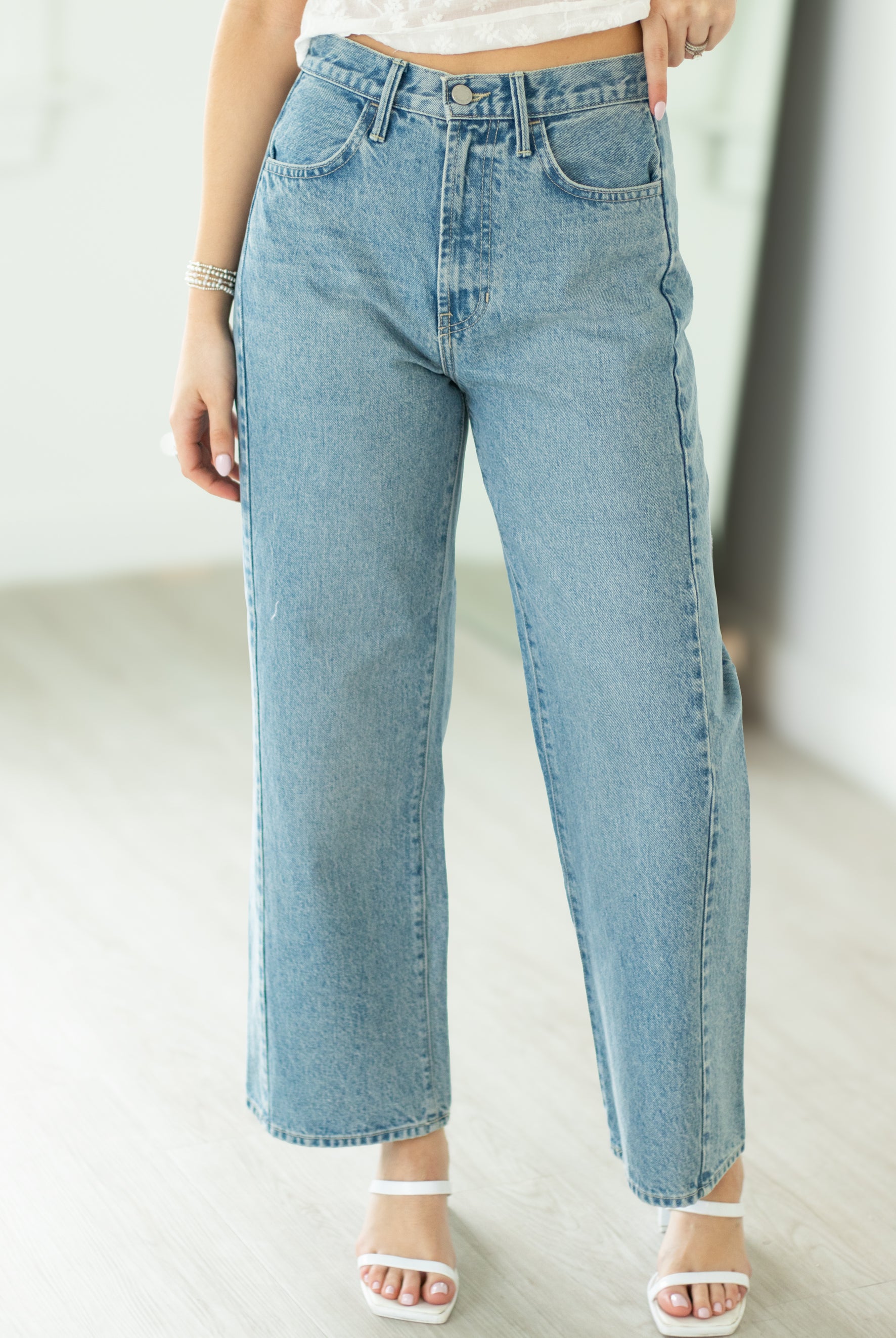 Light blue jeans worn by a person on a plain background