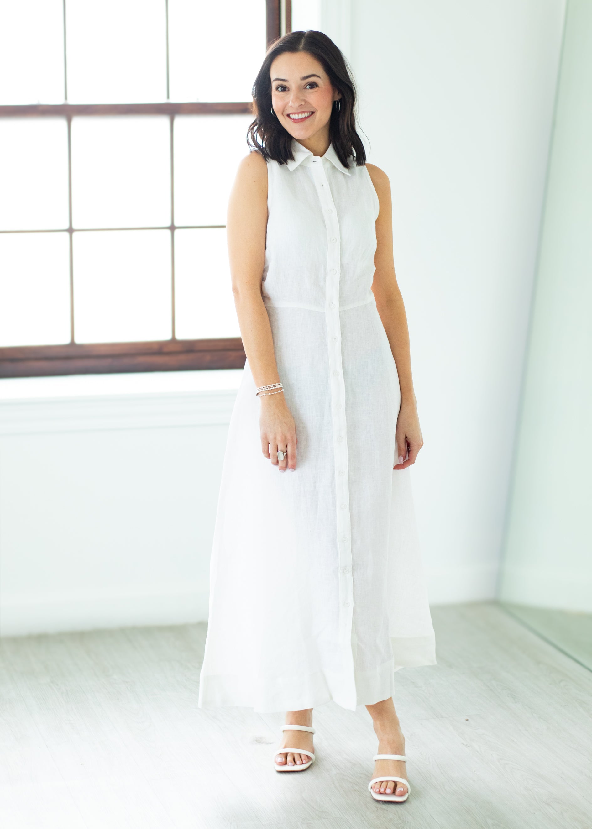 Woman wearing a long white dress against a beige background