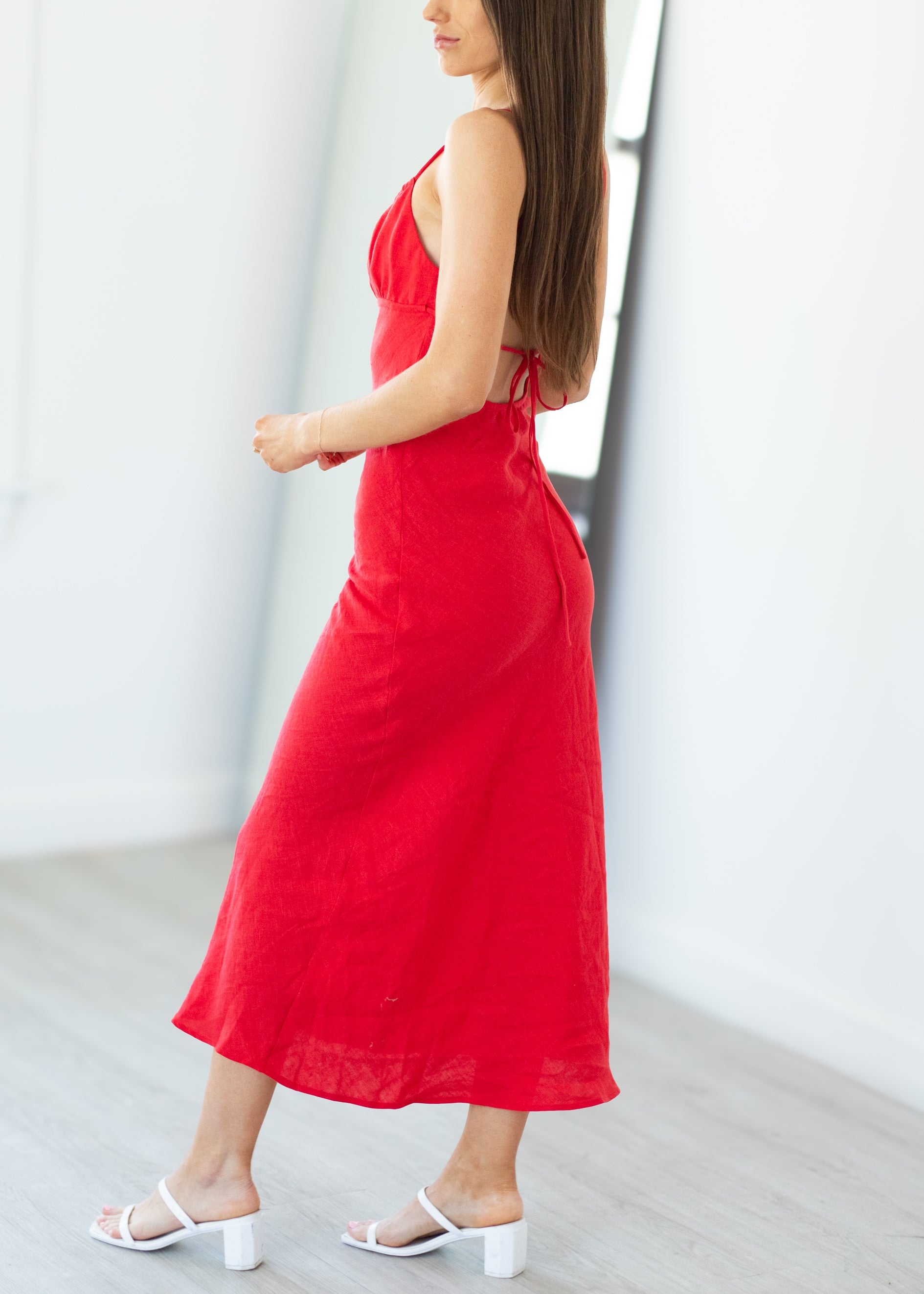 Woman wearing a red dress standing against a white background