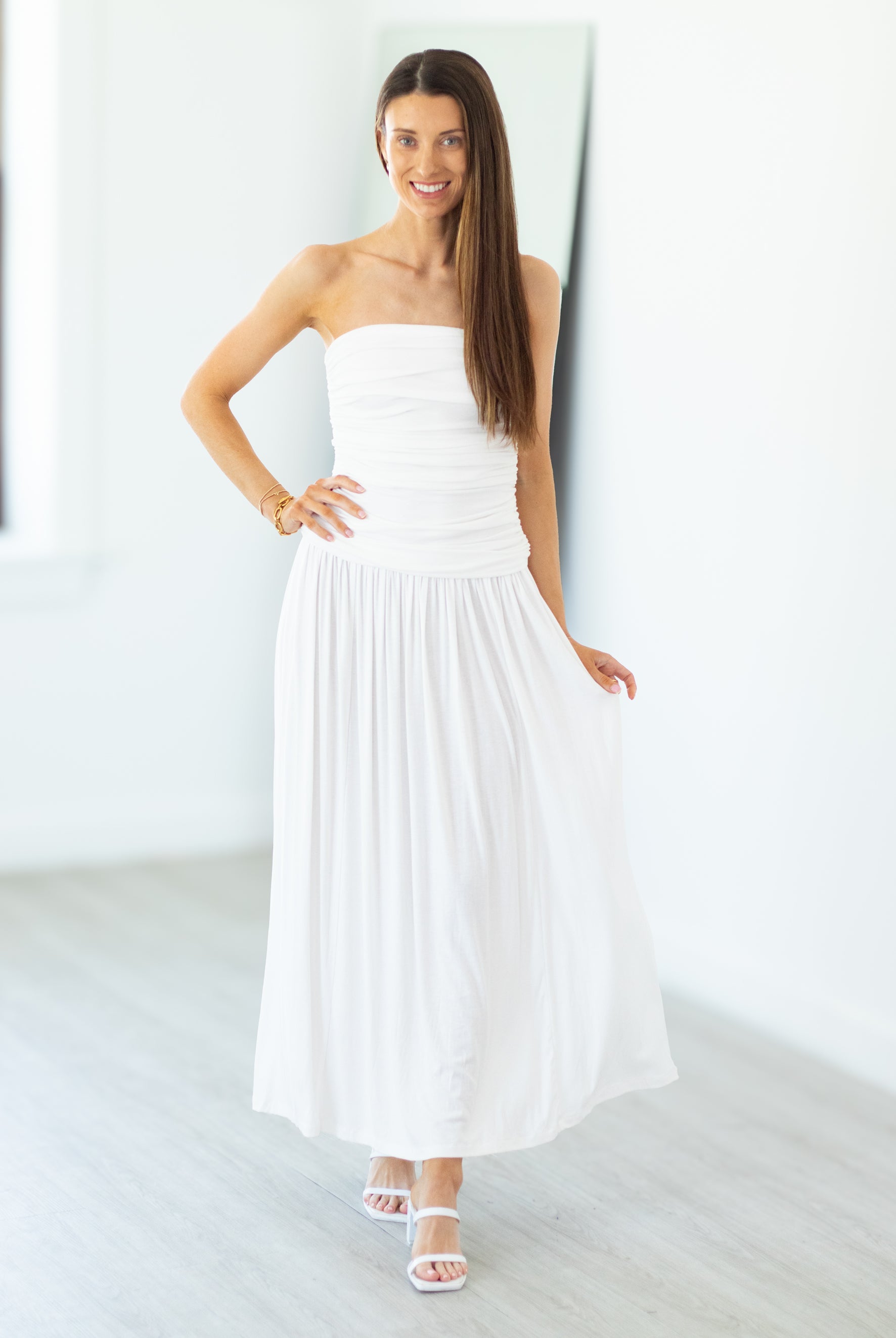 Woman wearing a white strapless dress in a minimalistic setting