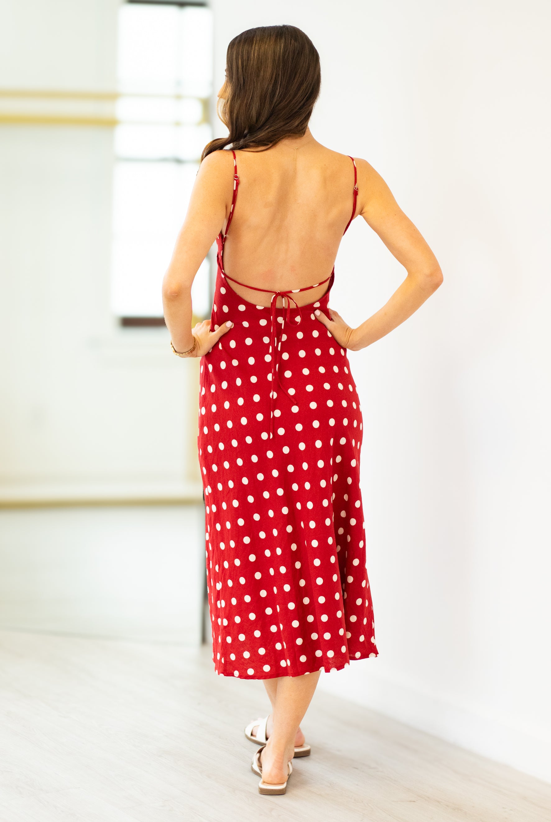 Woman wearing a red polka dot dress with a white background