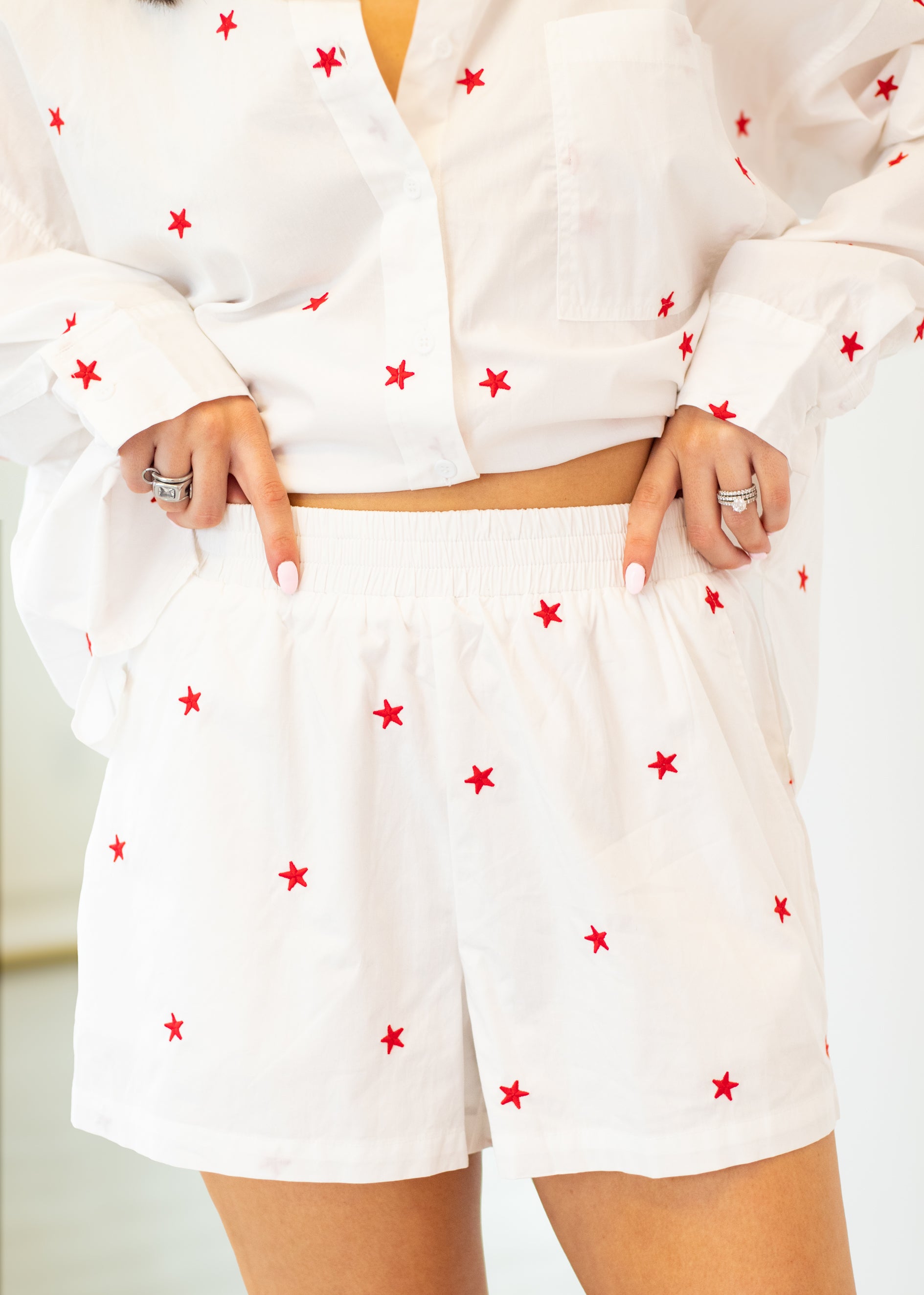 White outfit with red star patterns worn by a person on a white background