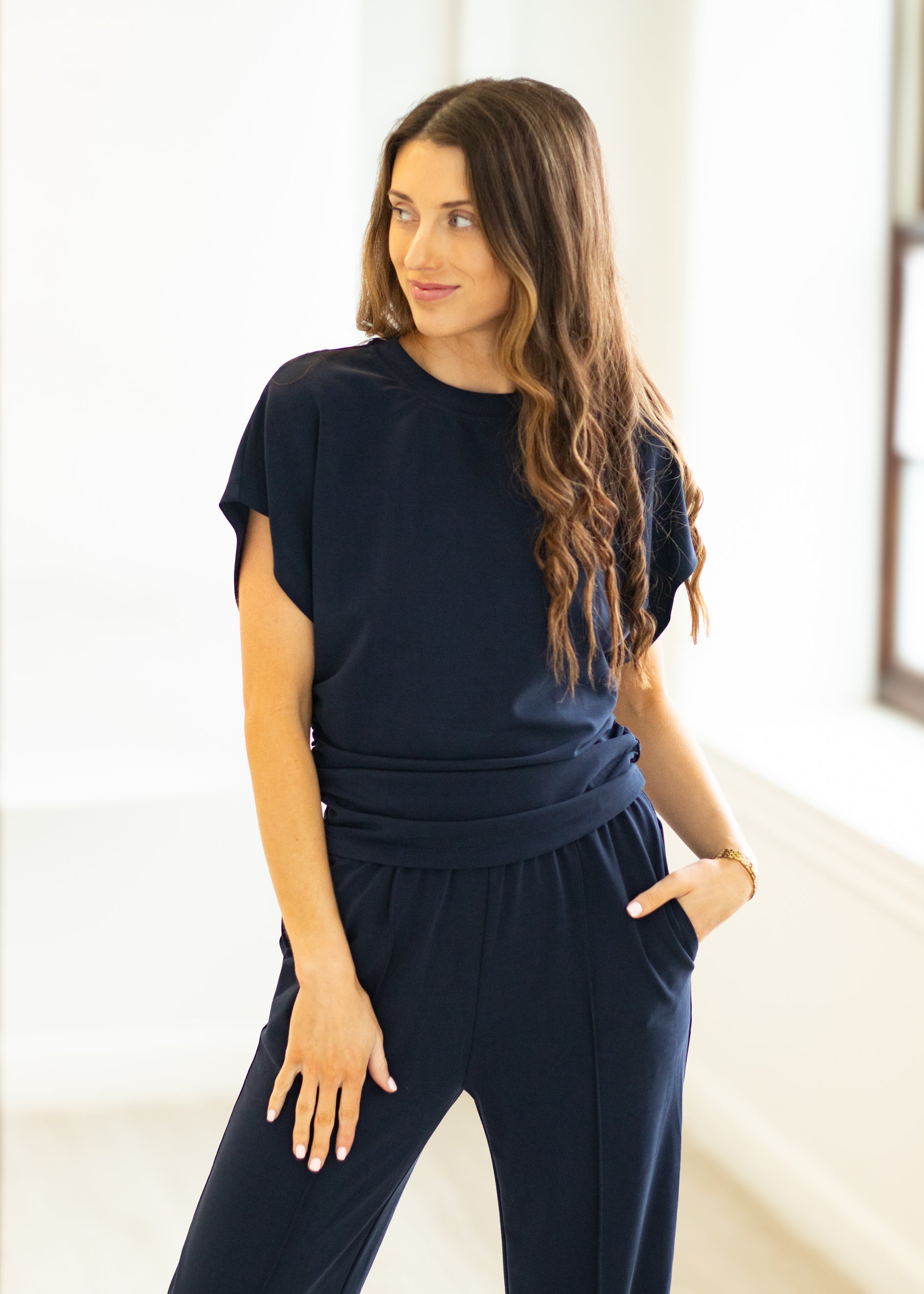 Woman wearing a navy blue outfit in a bright room