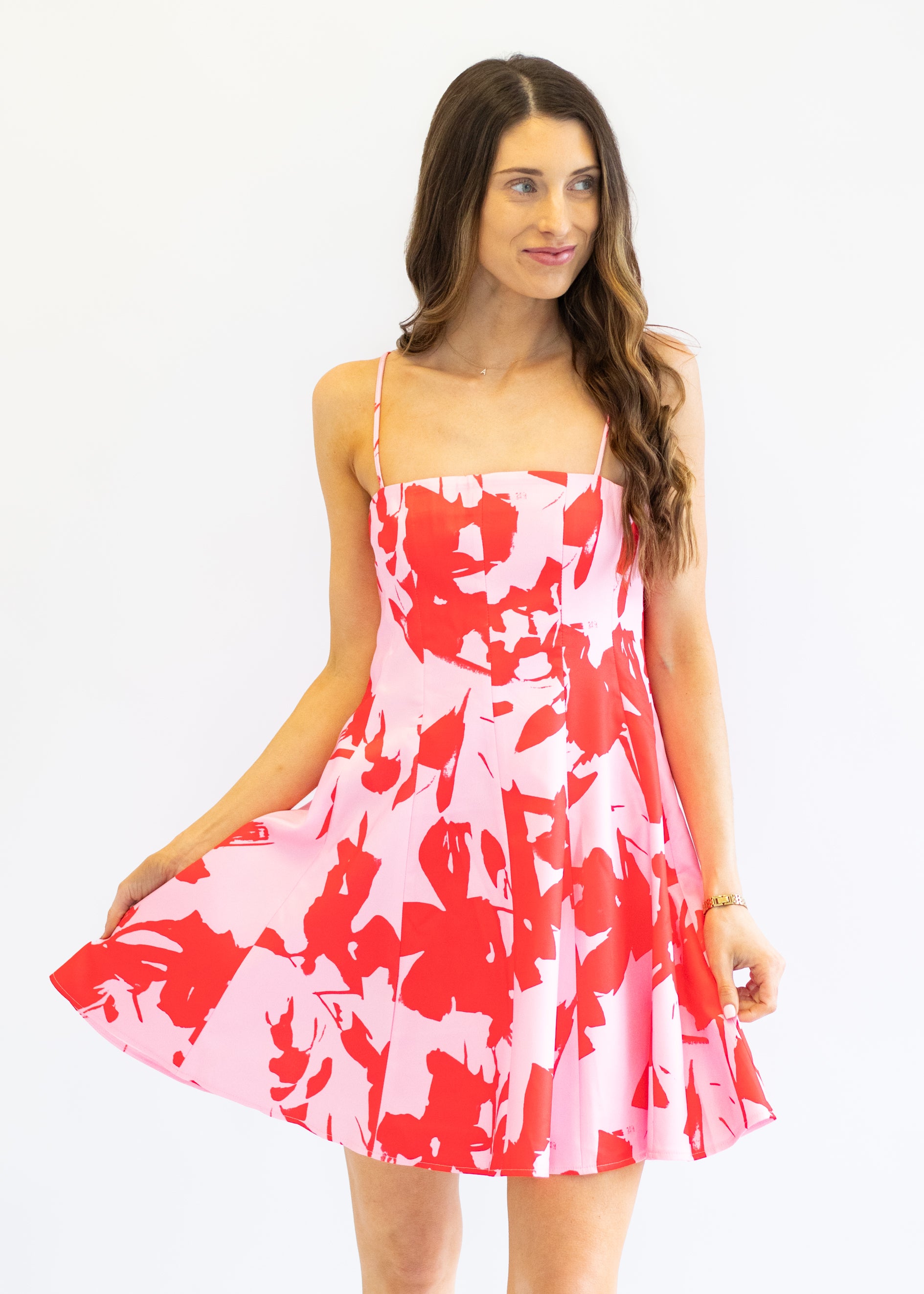 Woman wearing a red and white floral dress on a white background