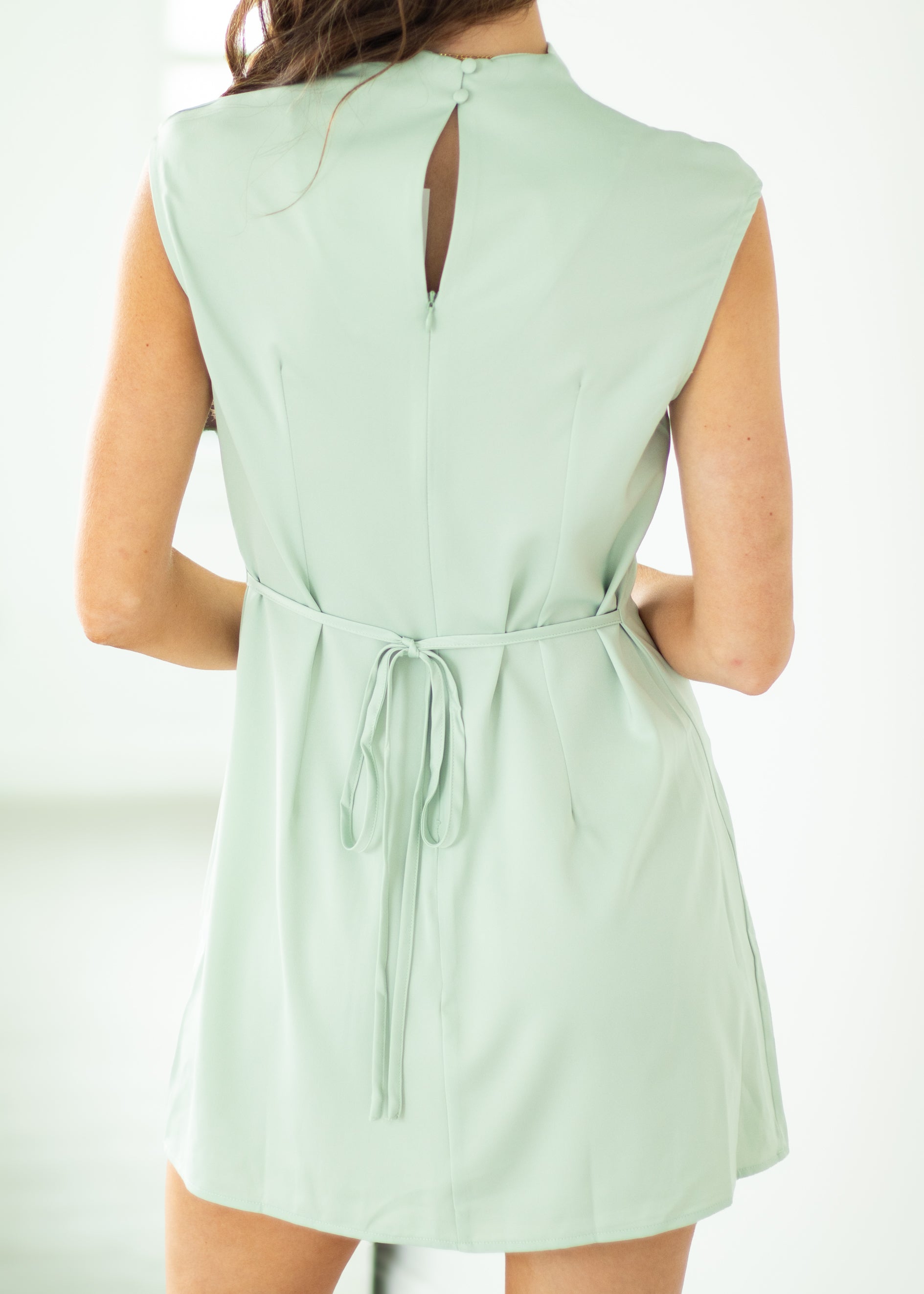 Light green romper with a tie waist on a white background