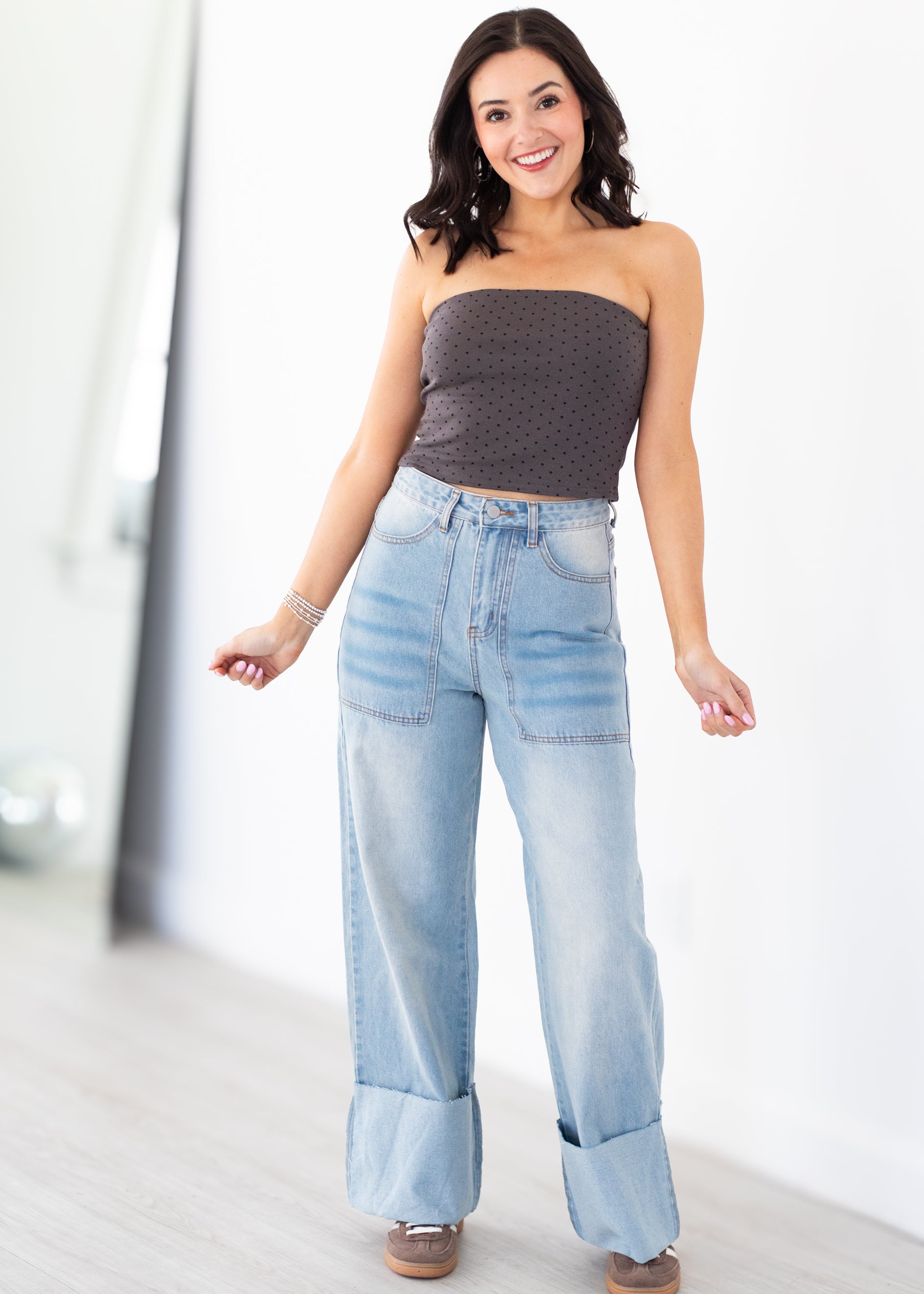 Woman wearing light blue jeans and a strapless top indoors
