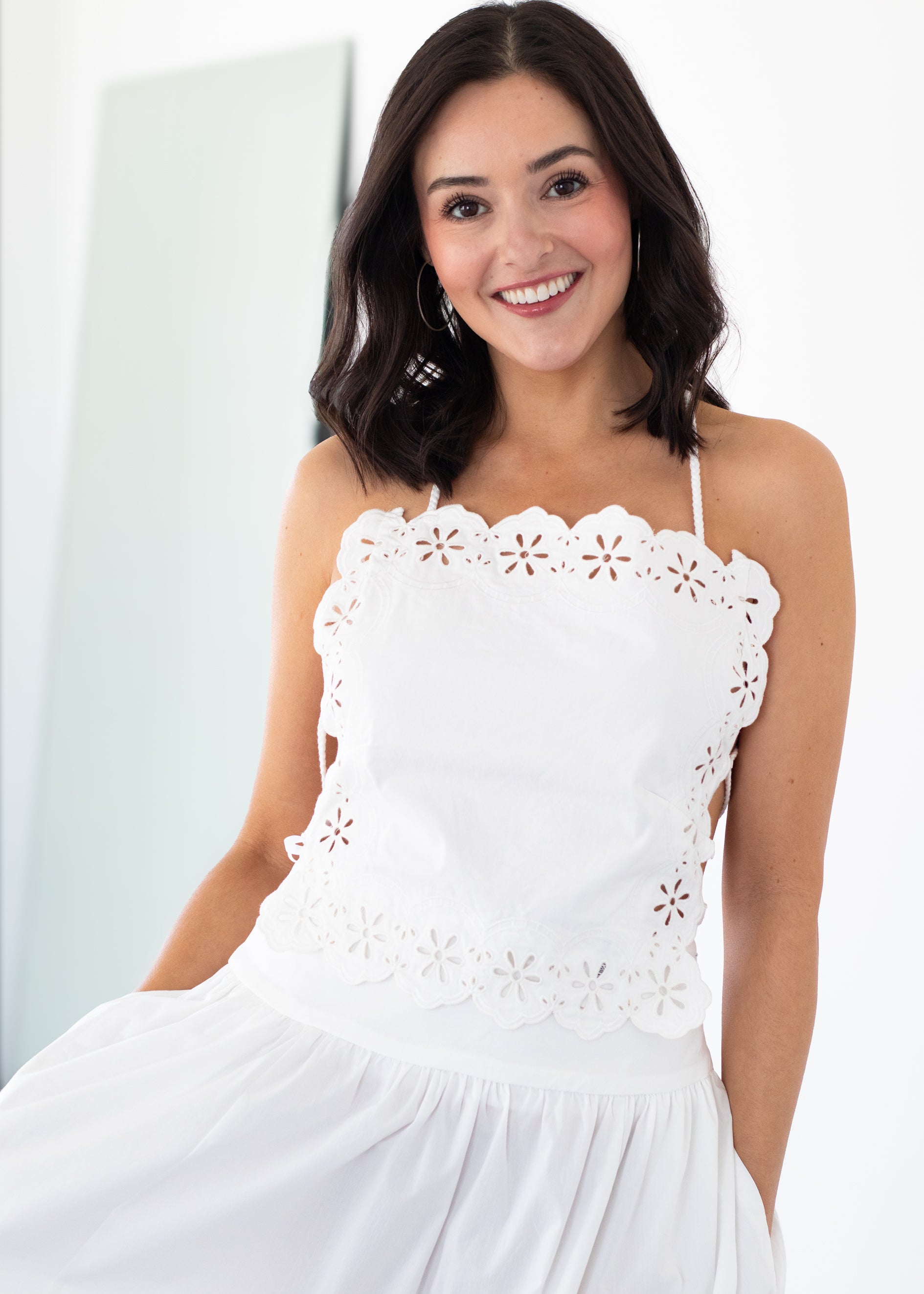 Woman wearing a white lace matching set against a light background