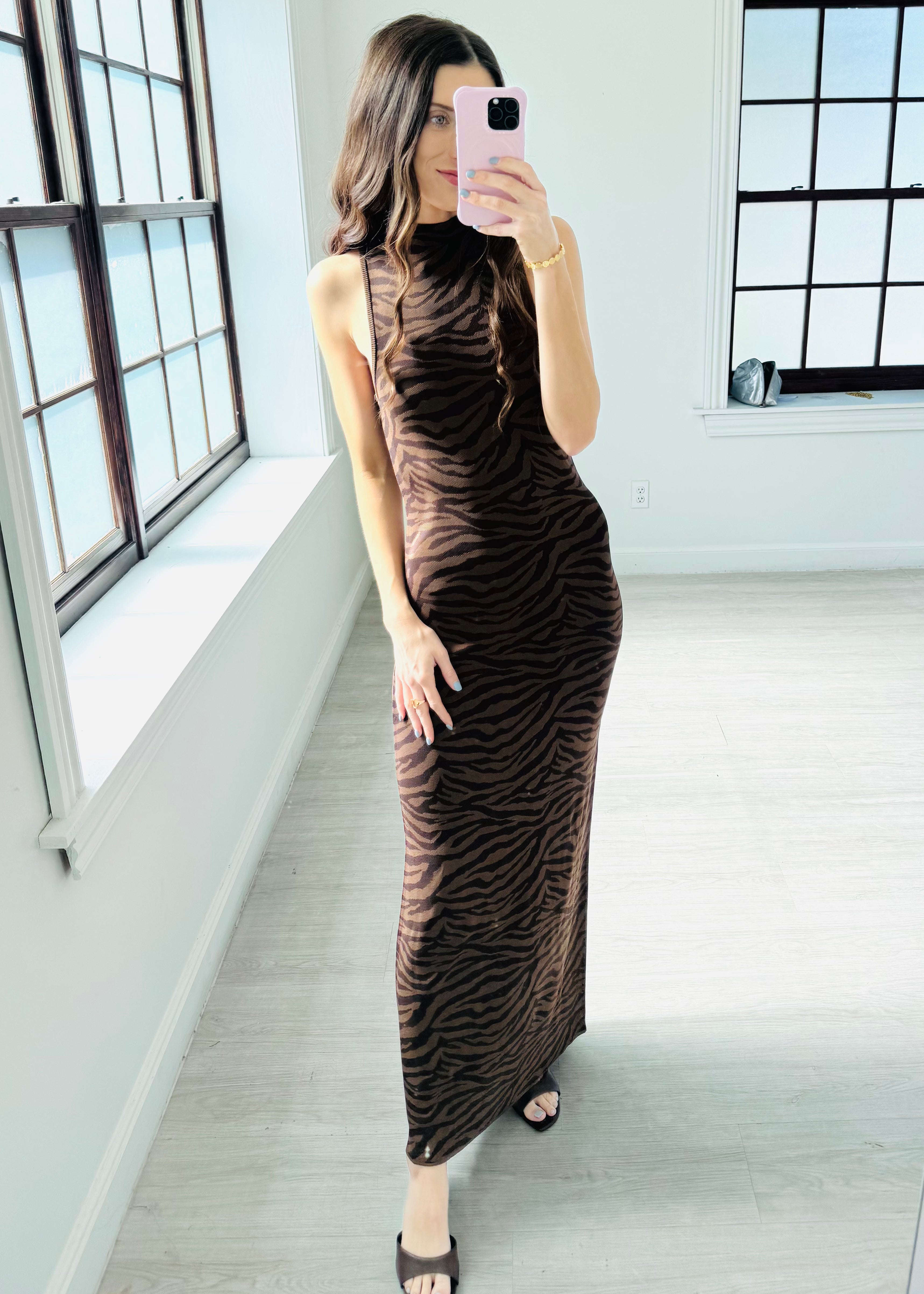 Woman wearing a brown zebra print dress on a white background