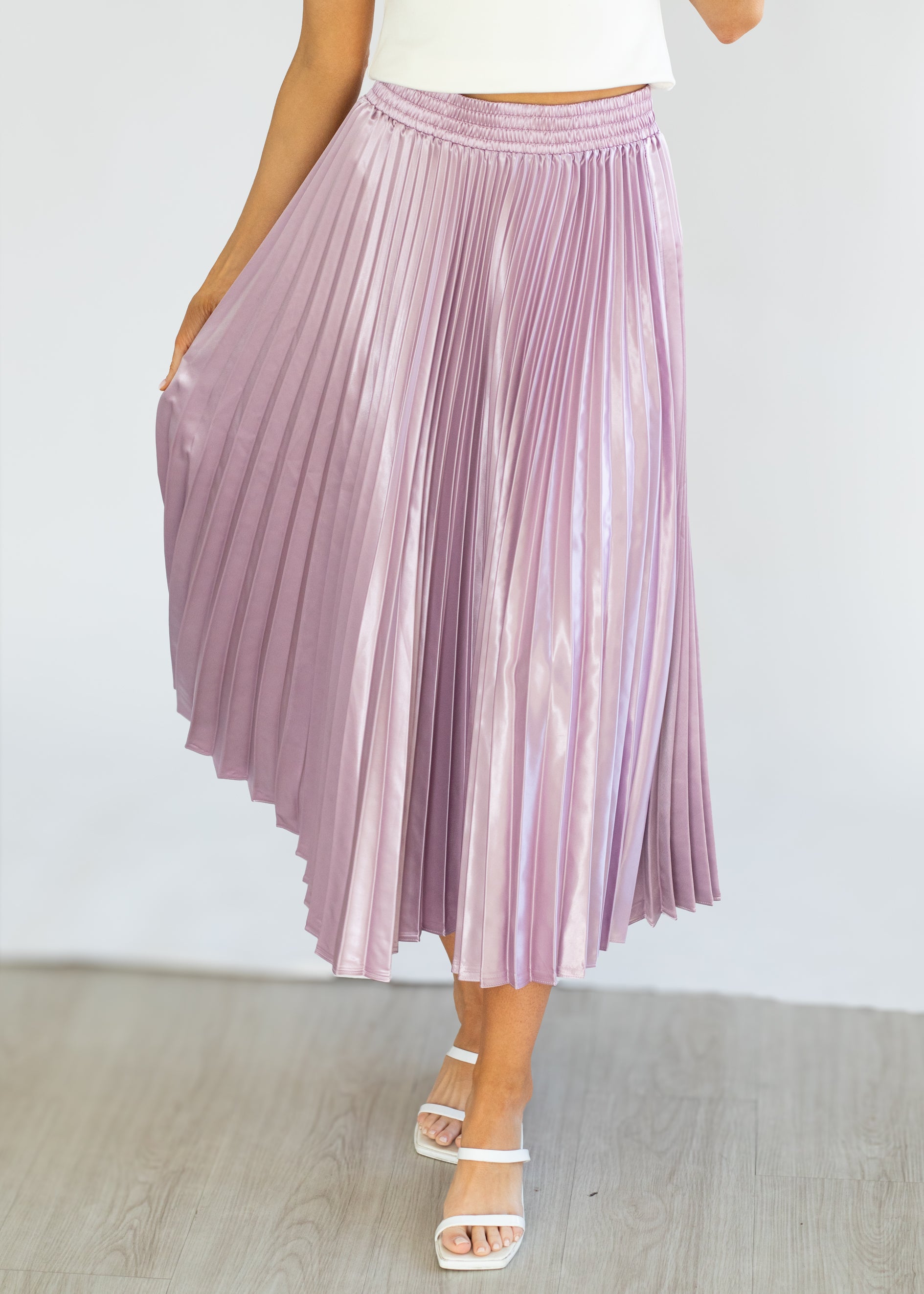 Purple pleated skirt worn by a person on a white background