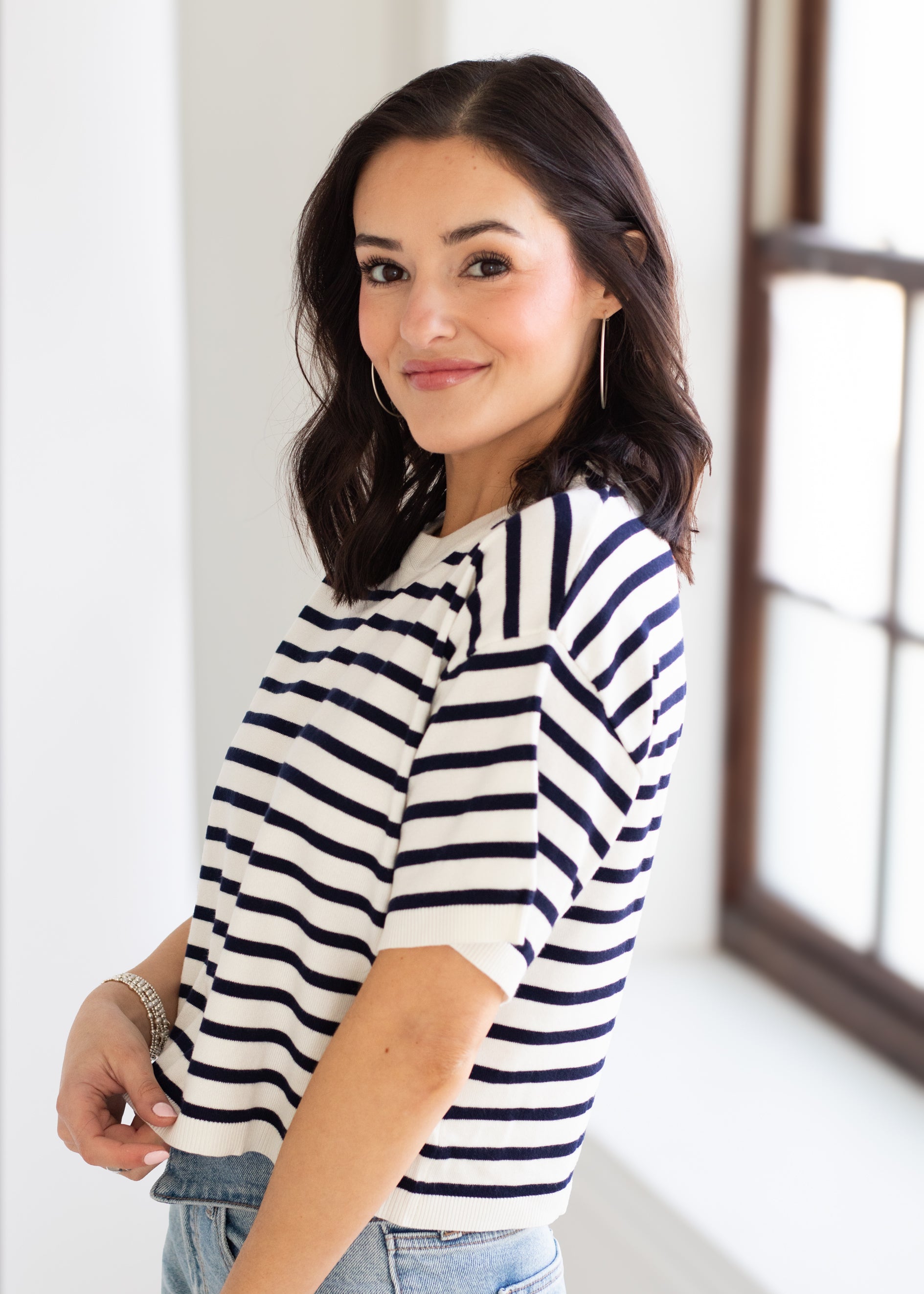 Woman wearing a striped shirt in a bright room