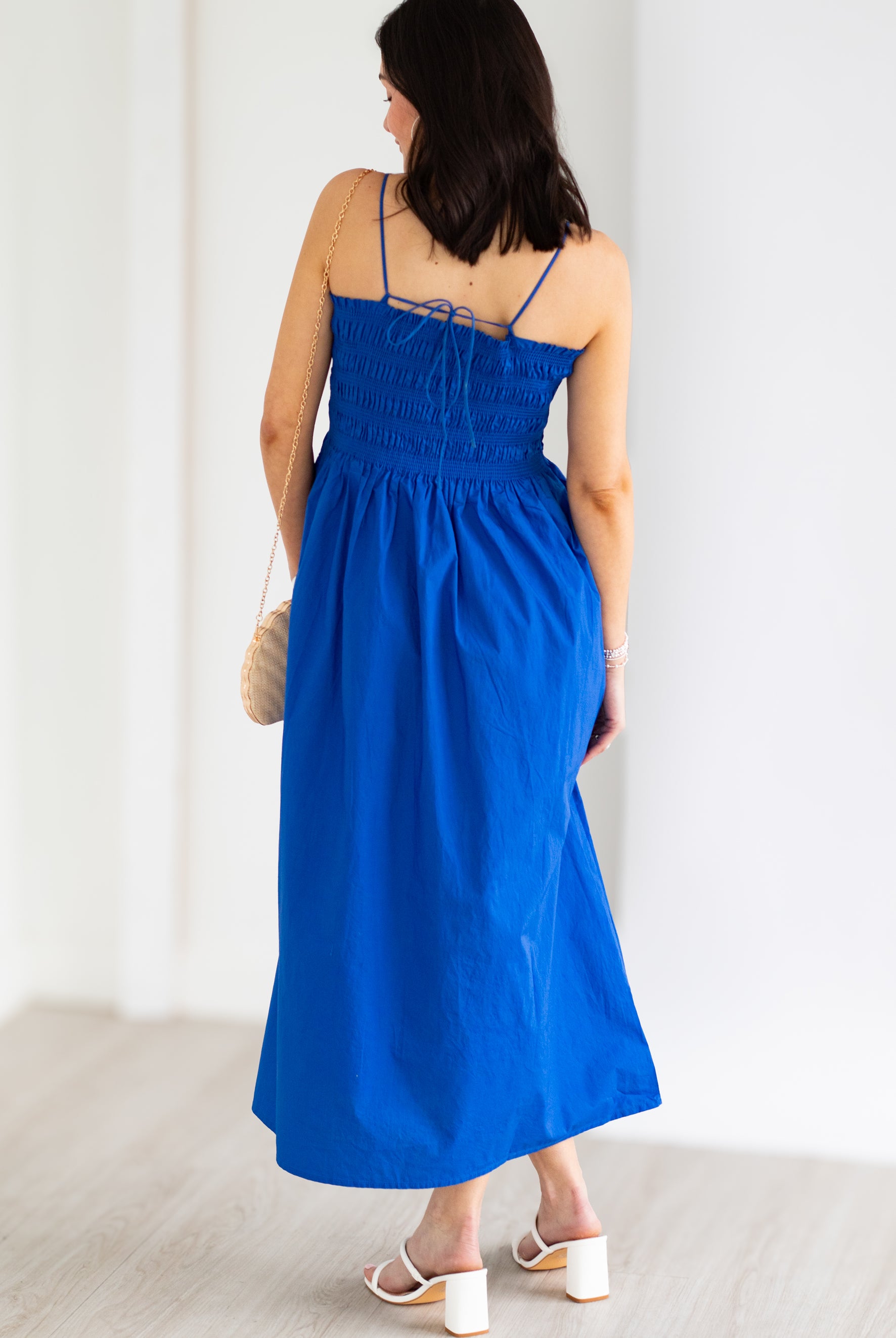 Woman wearing a blue dress against a white background