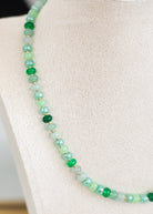 Green beaded necklace on a mannequin bust