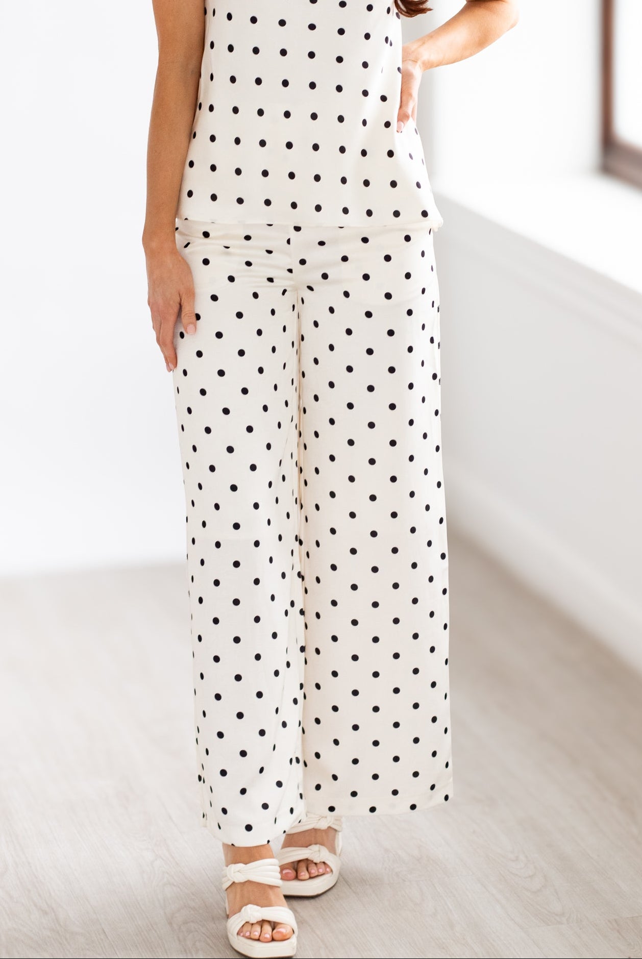 Woman wearing a strapless polka dot outfit in a minimal indoor setting